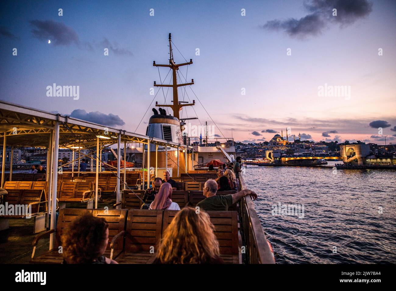Istanbul, Turquie. 03rd septembre 2022. Les gens vus assis sur la terrasse des lignes de la ville ferry au coucher du soleil à Istanbul et le pont de Galata en arrière-plan avec les nuages ont créé une vue magnifique. Crédit : SOPA Images Limited/Alamy Live News Banque D'Images