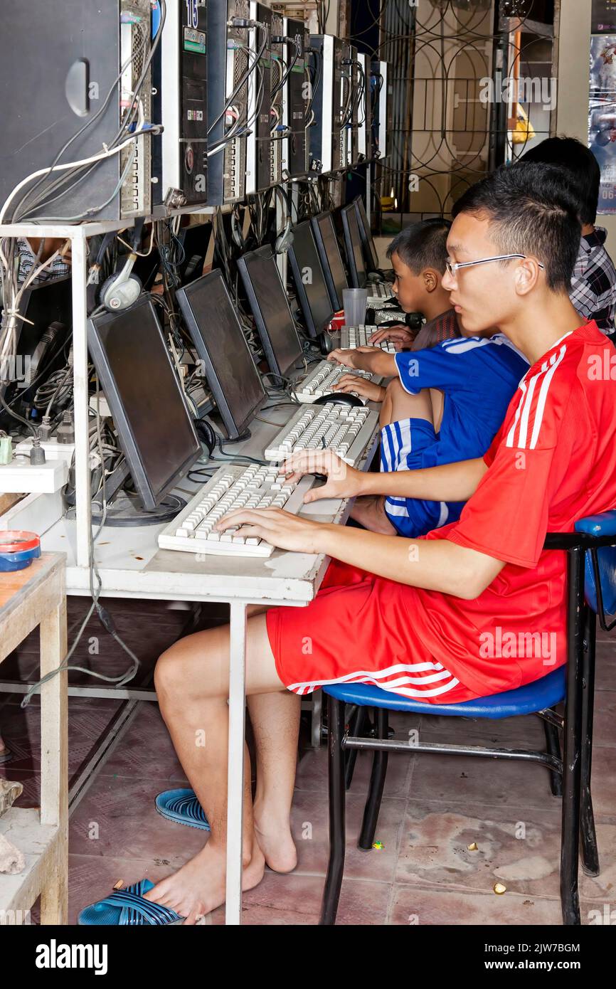 Jeunes étudiants travaillant sur l'ordinateur dans la boutique Internet, Hai Phong, Vietnam Banque D'Images