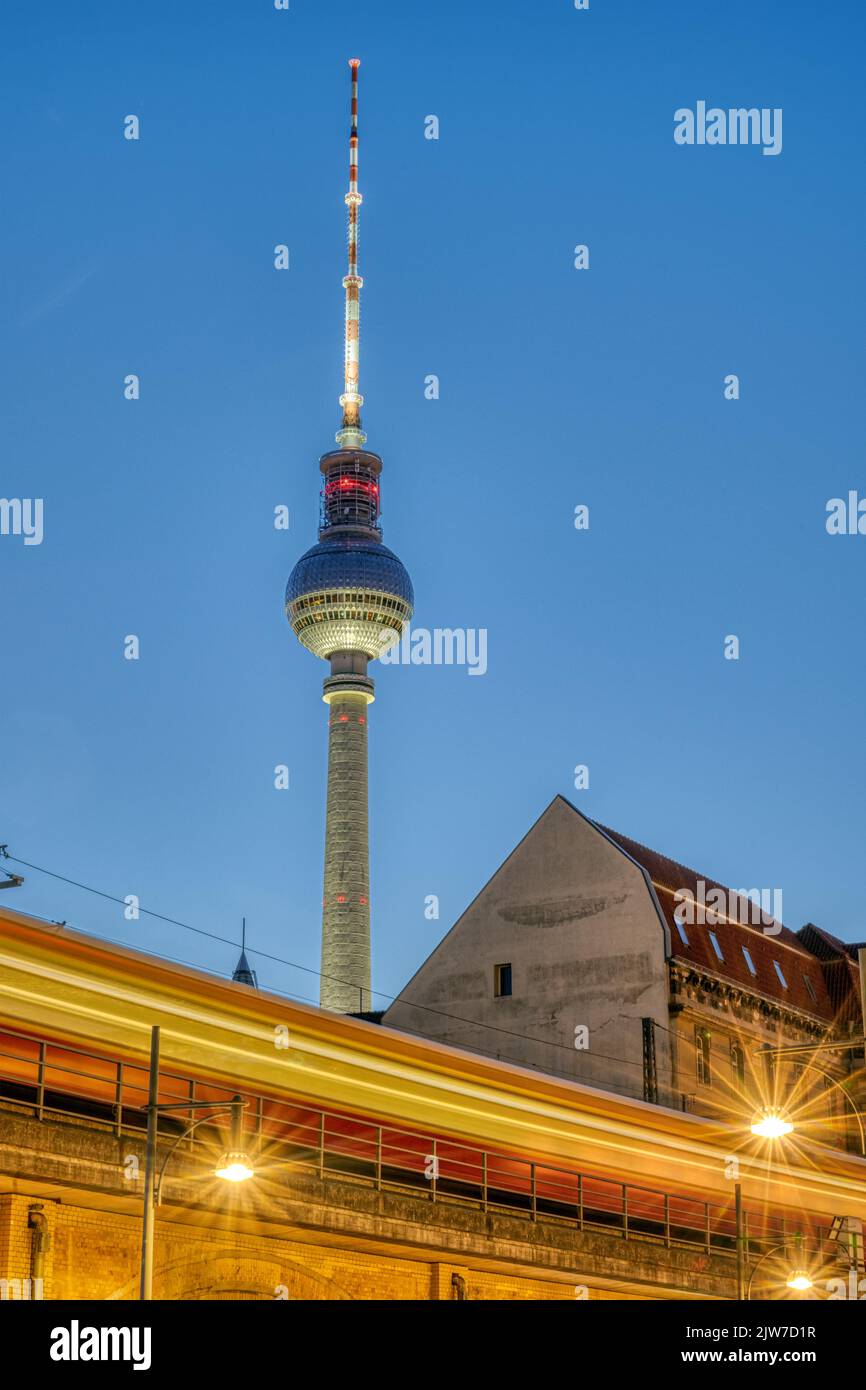 La célèbre tour de télévision de Berlin au crépuscule avec un train de banlieue à mouvement flou Banque D'Images