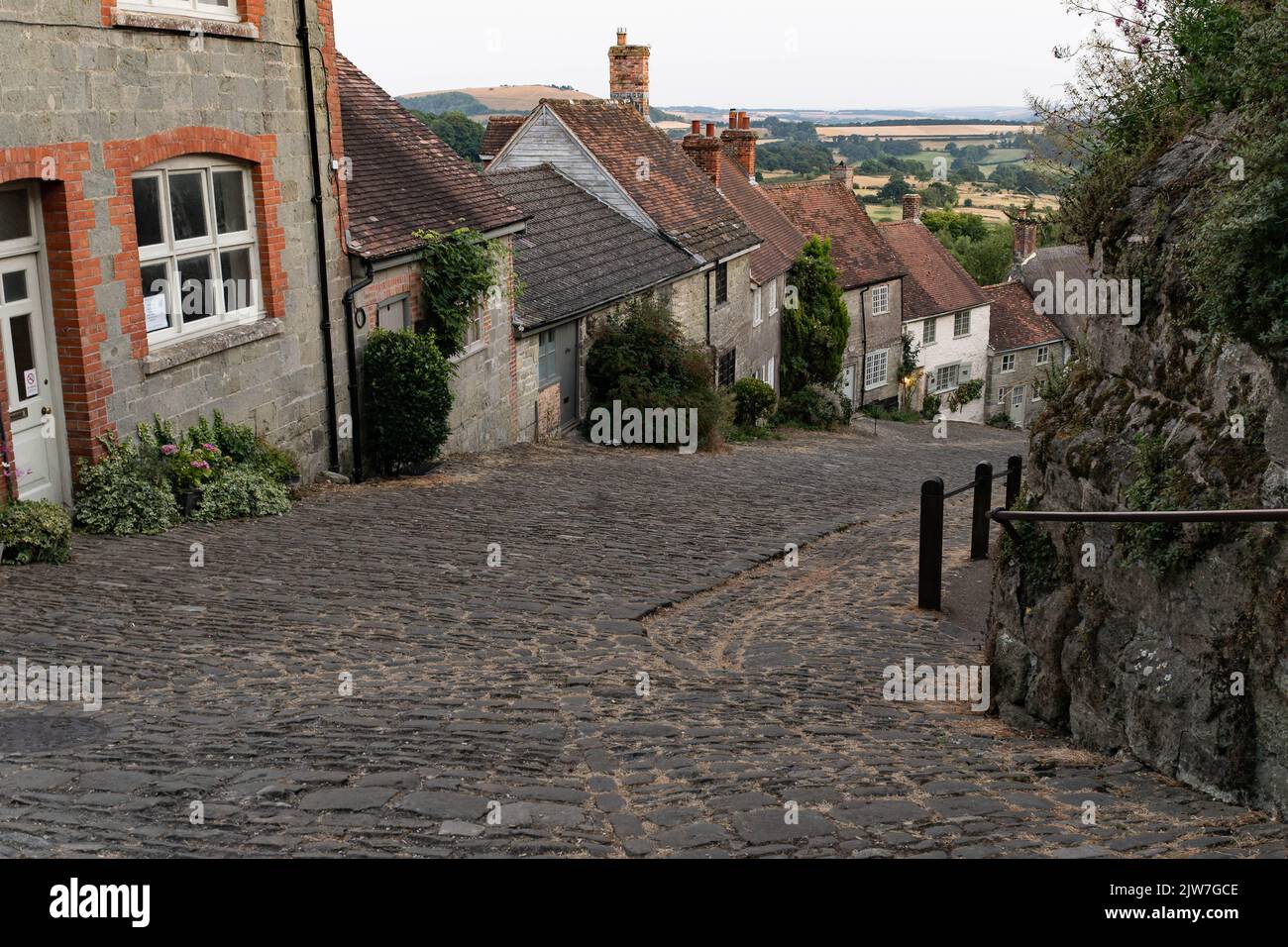 Rue pavée historique avec des chalets en pierre traditionnels dans le village du Dorset Banque D'Images