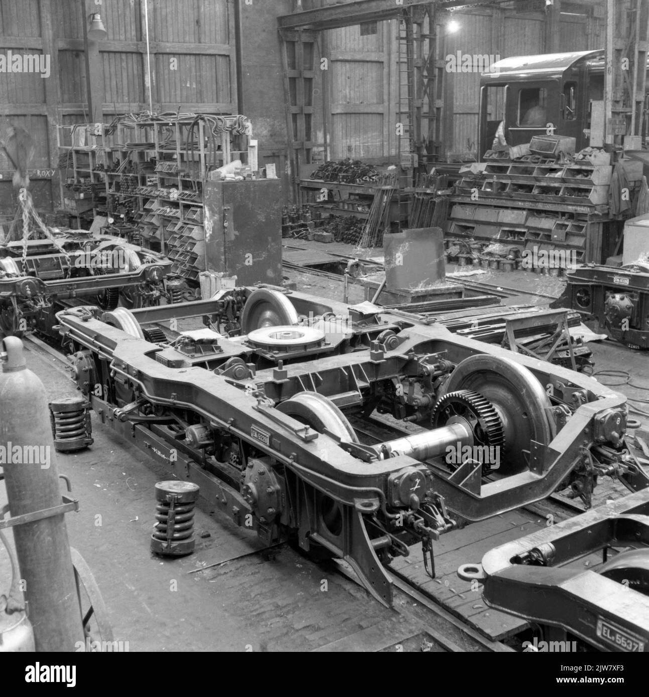 Image en construction de bogies pour les trains électriques Plan F (Mat. 1954) pour la N.S. Au Wagon et Bruggenfabriek Werkspoor N.V. à Utrecht. En arrière-plan, une locomotive diesel-électrique de la série 450 (nos 451-460) en construction pour la N.-É. Banque D'Images