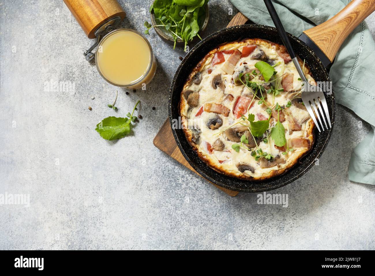Petit-déjeuner italien. Omelette rustique (frittata) avec champignons et bacon sur une poêle en fonte. Vue de dessus. Copier l'espace. Banque D'Images