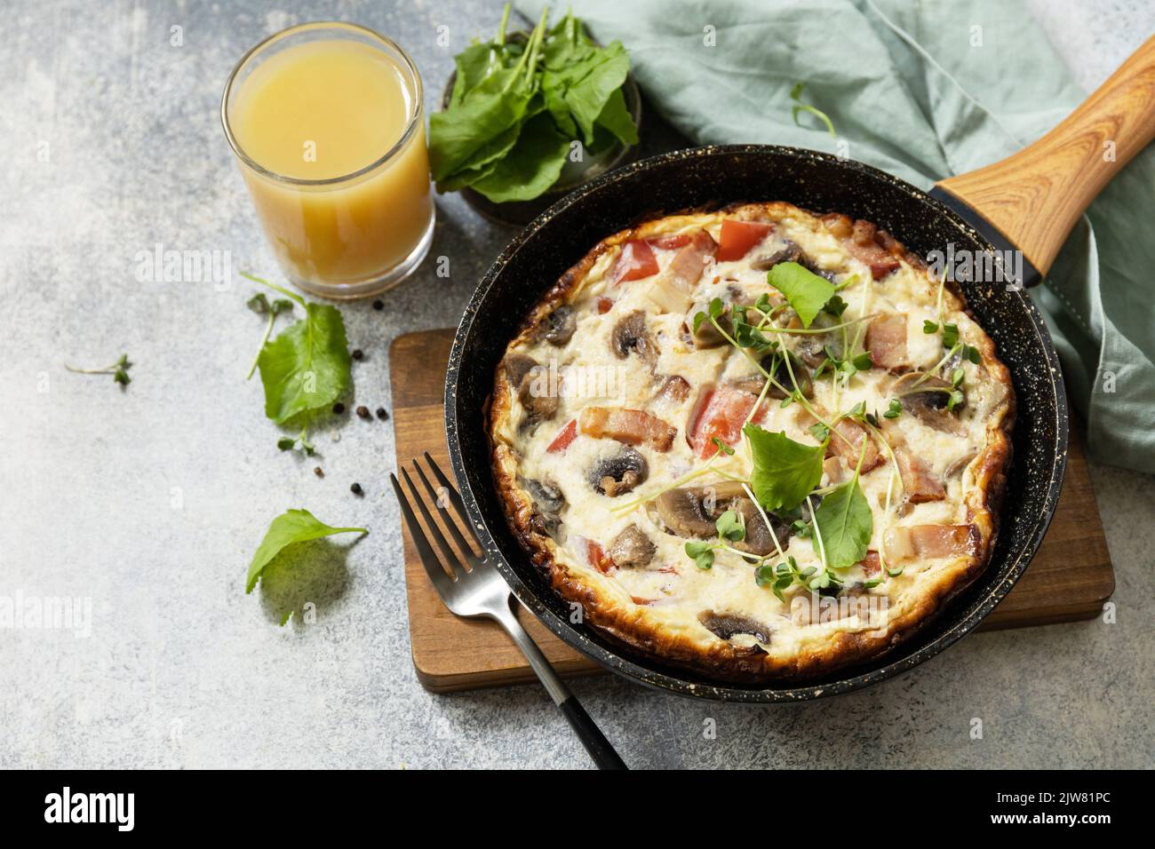 Petit-déjeuner italien. Omelette rustique (frittata) avec champignons et bacon sur une poêle en fonte. Copier l'espace. Banque D'Images