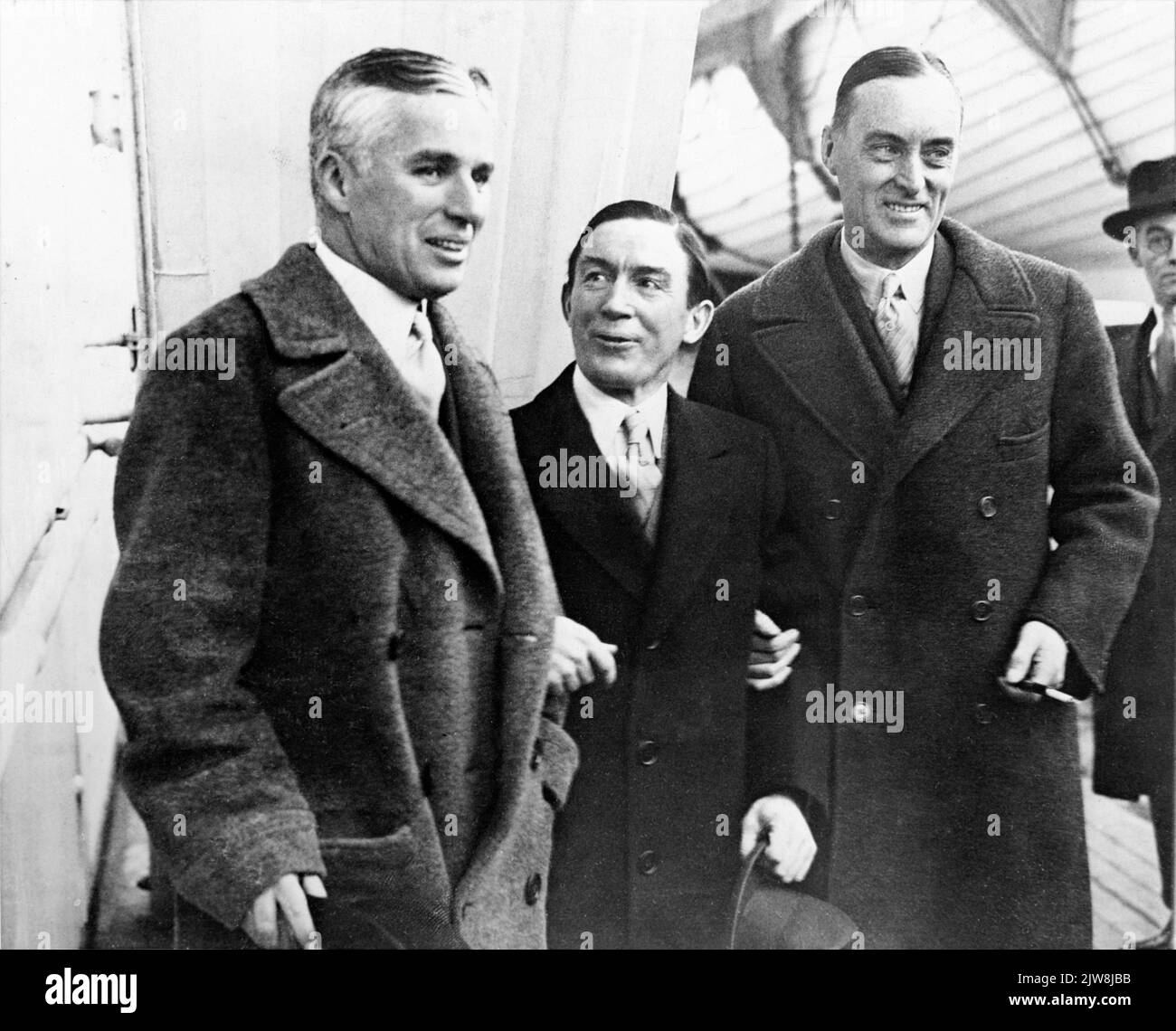 CHARLIE CHAPLIN (arrivant pour la première de Londres de son dernier film LUMIÈRES DE LA VILLE) jockey STEVE DONOGHUE et capitaine MALCOLM CAMPBELL détenteur du record de vitesse terrestre sur le pont de la MAURETANIA à son arrivée à Plymouth, en Angleterre, en février 1931 Banque D'Images