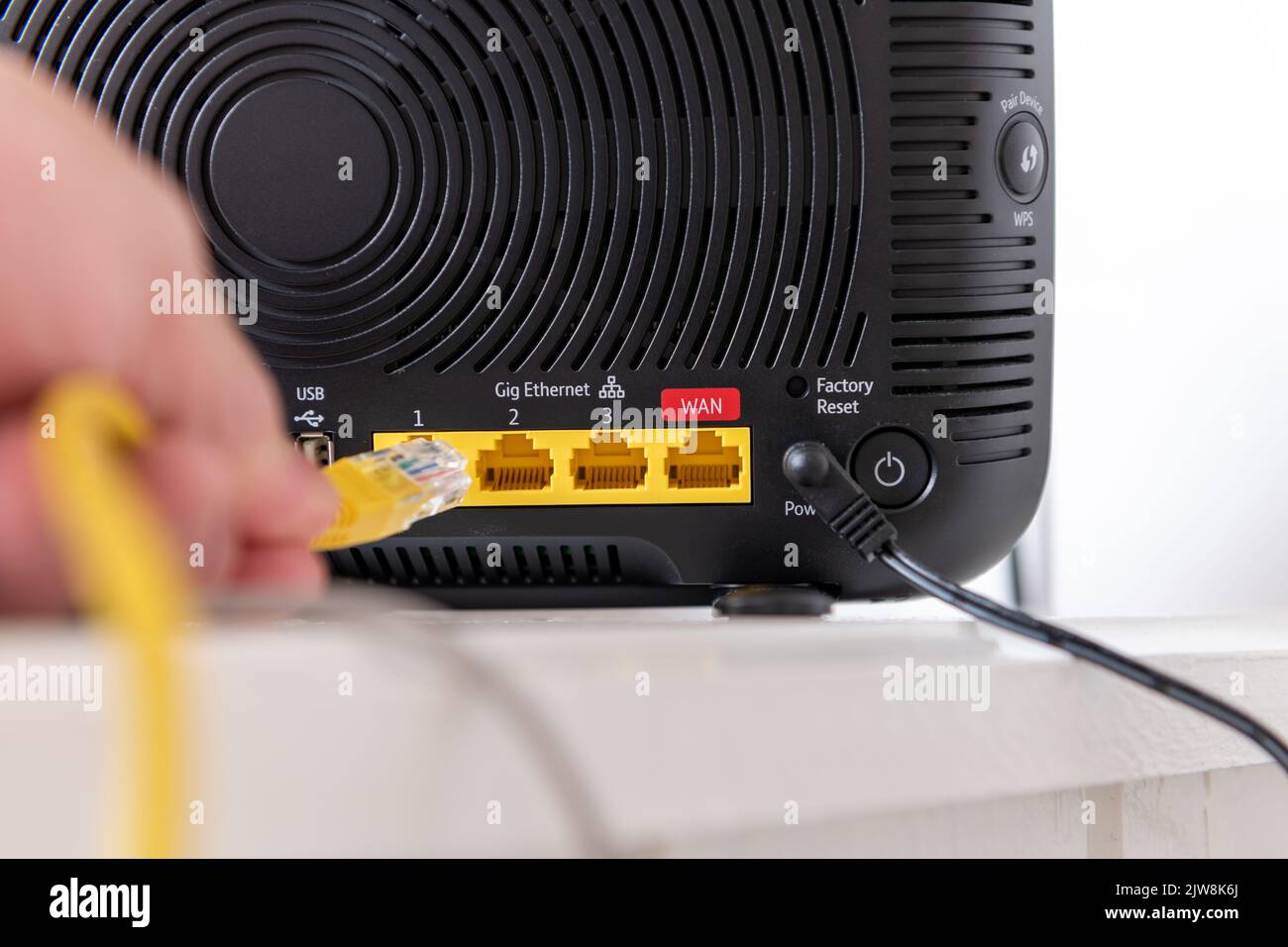 Personne connectant un périphérique à un routeur Internet. Banque D'Images