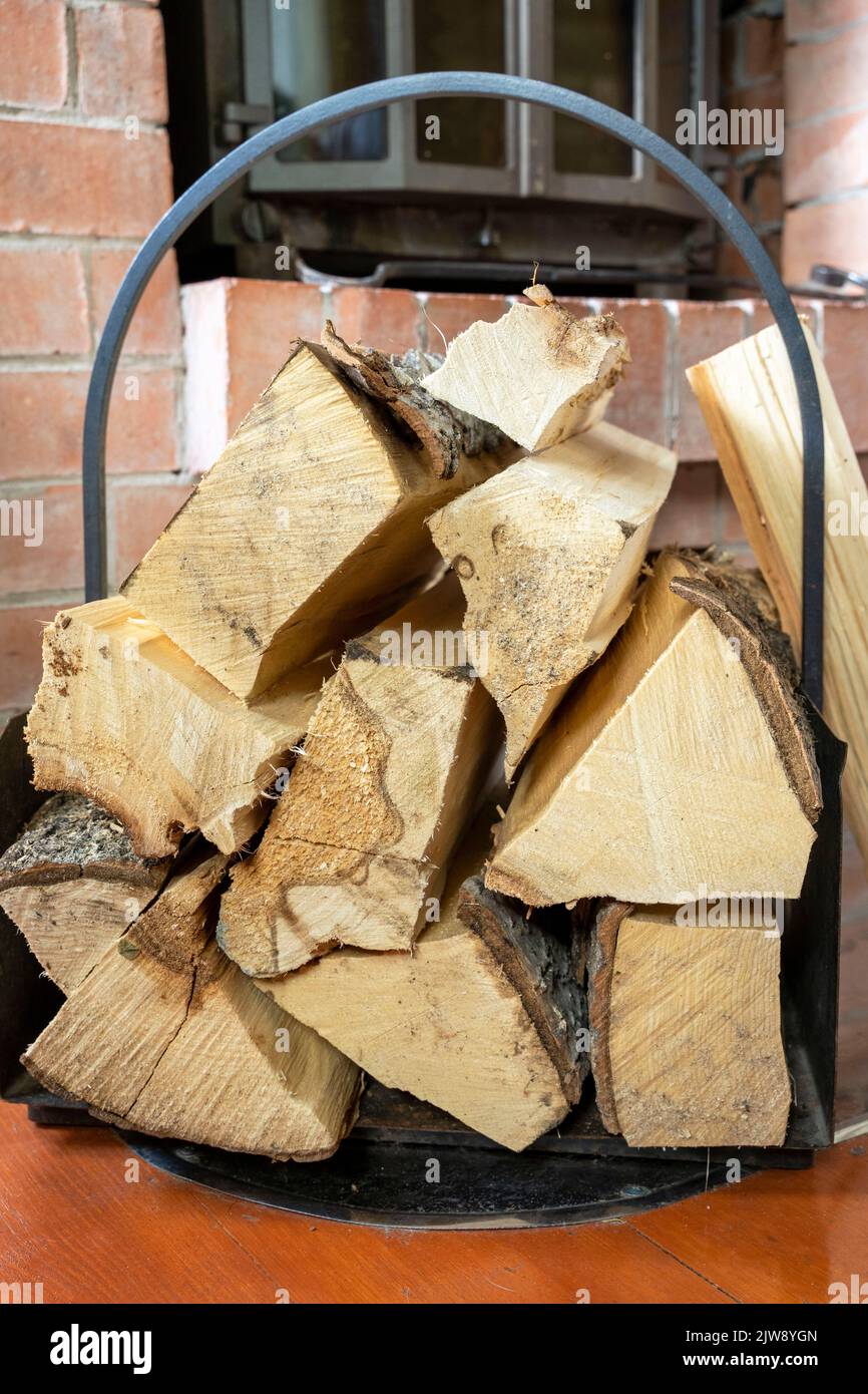 bois de chauffage haché empilé dans la pile de bois contre le fond de la cheminée Banque D'Images