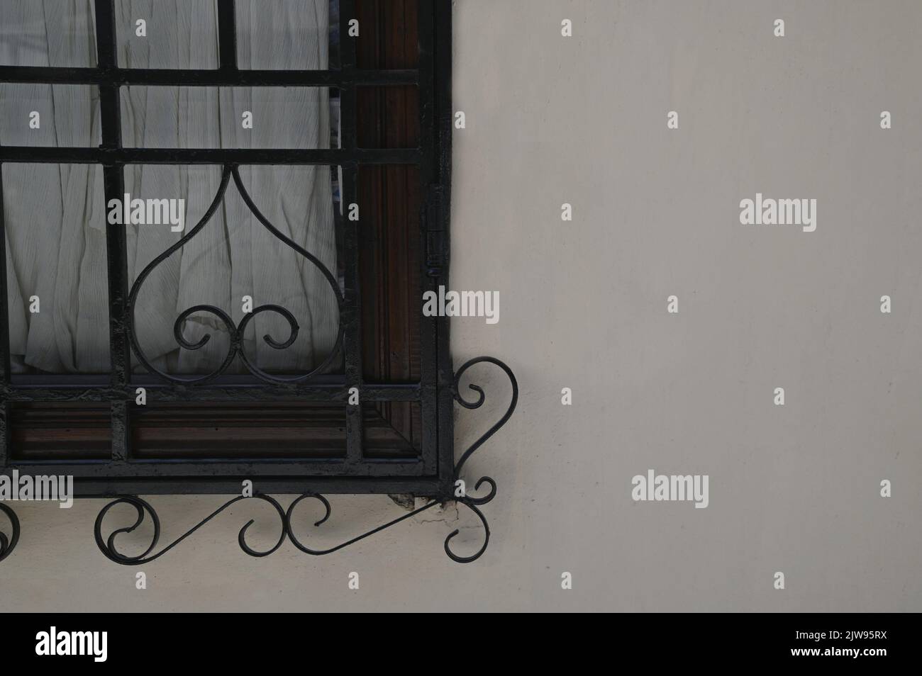Ancienne maison rurale fenêtre en bois avec grilles en fer forgé artisanales sur un mur blanchi à la chaux. Banque D'Images