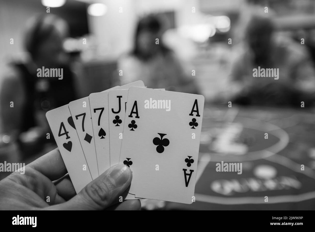 Une main de poker pendant un jeu en noir et blanc Banque D'Images