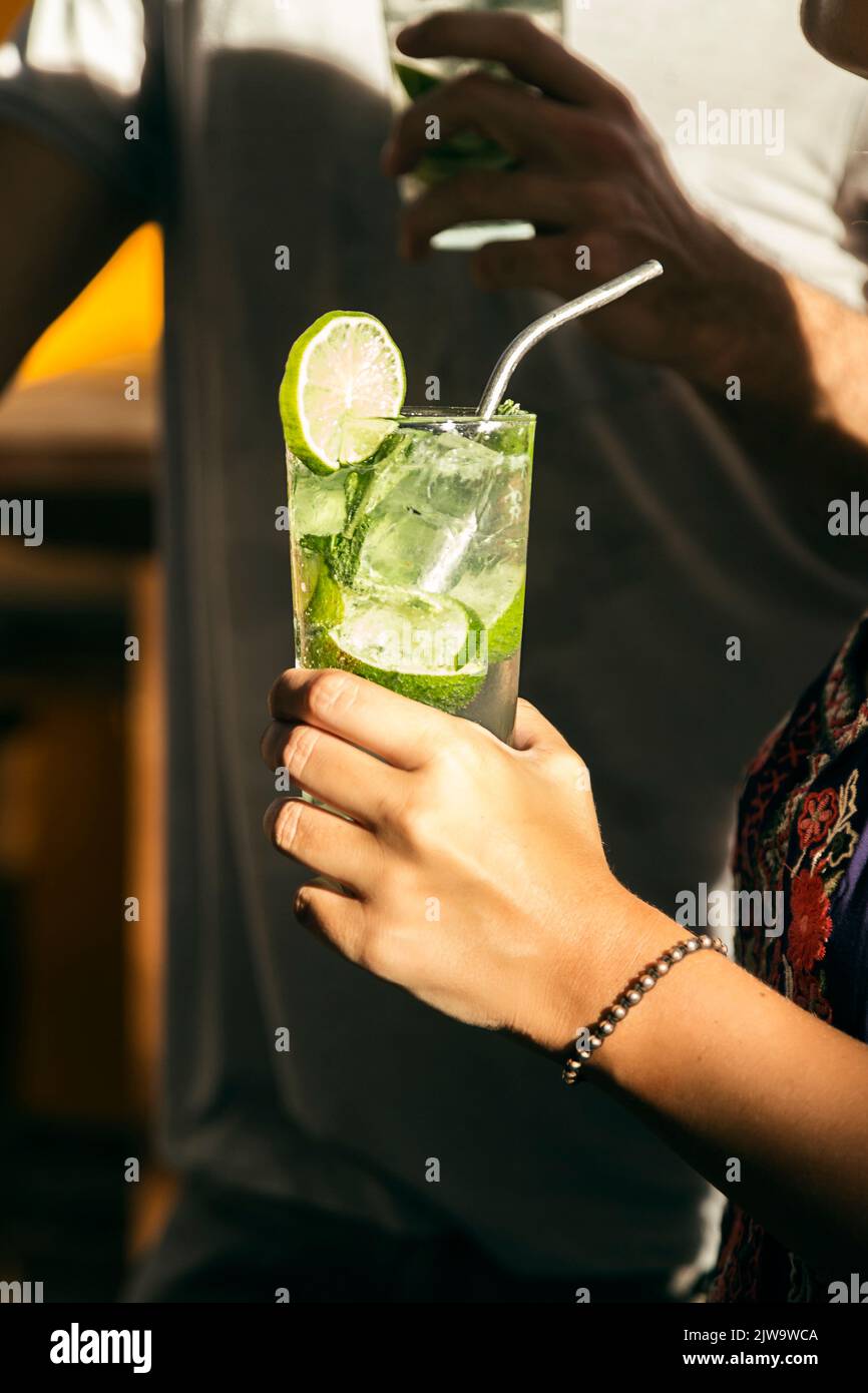 Femme au bar avec un cocktail à la main tout en appréciant une nuit de plaisir. Vie nocturne Banque D'Images