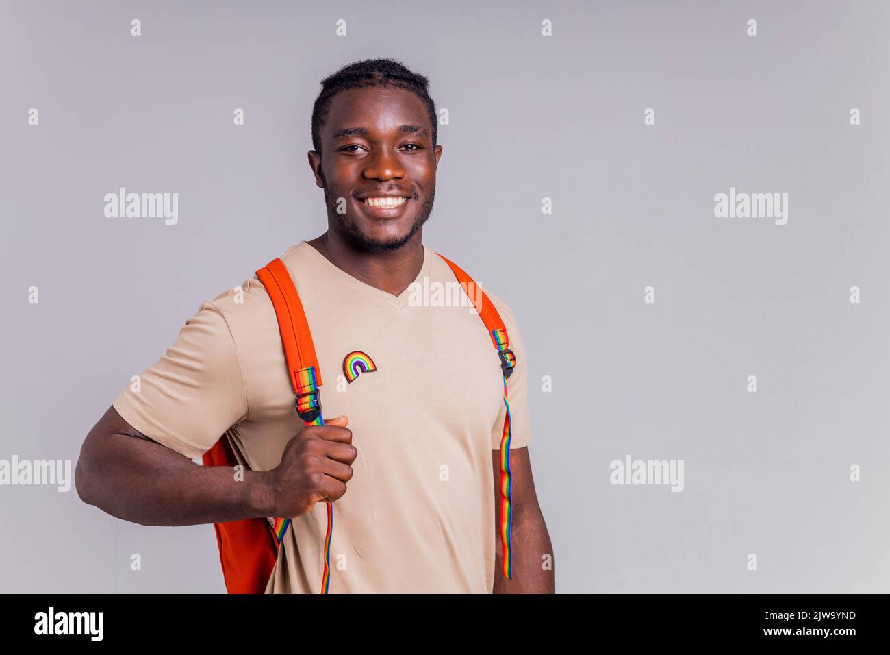 étudiant hispanique avec badge arc-en-ciel sur le t-shirt en studio isolat Banque D'Images