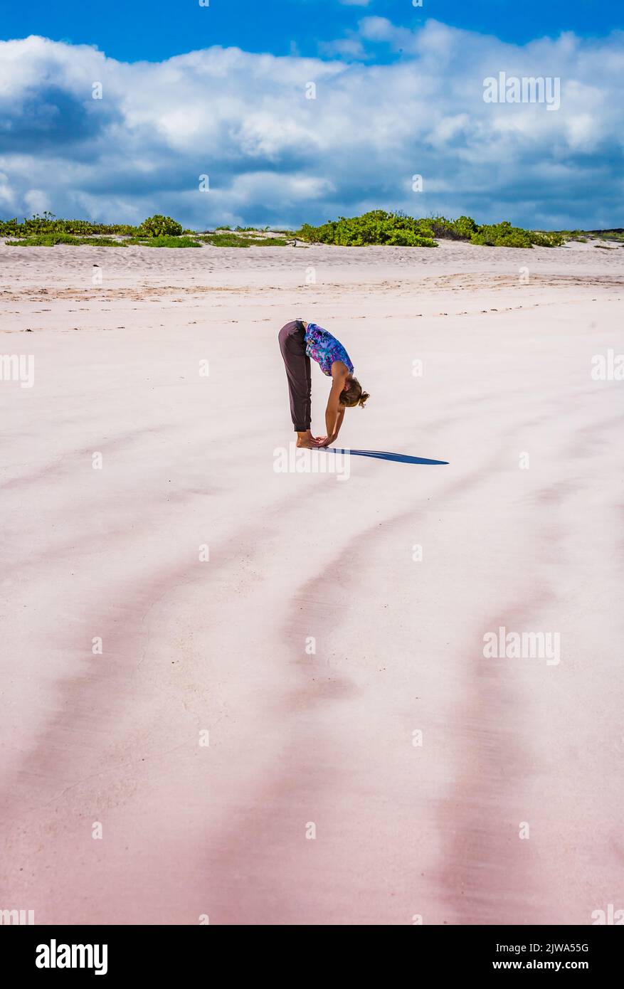 Instructeur de yoga se produit sur la plage de Cerro Brujo aux Galapagos Banque D'Images