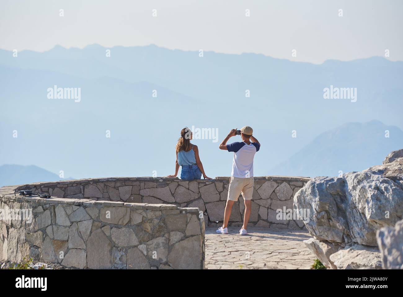 Un homme prend une photo pour une femme contre les montagnes lors de ses déplacements Banque D'Images