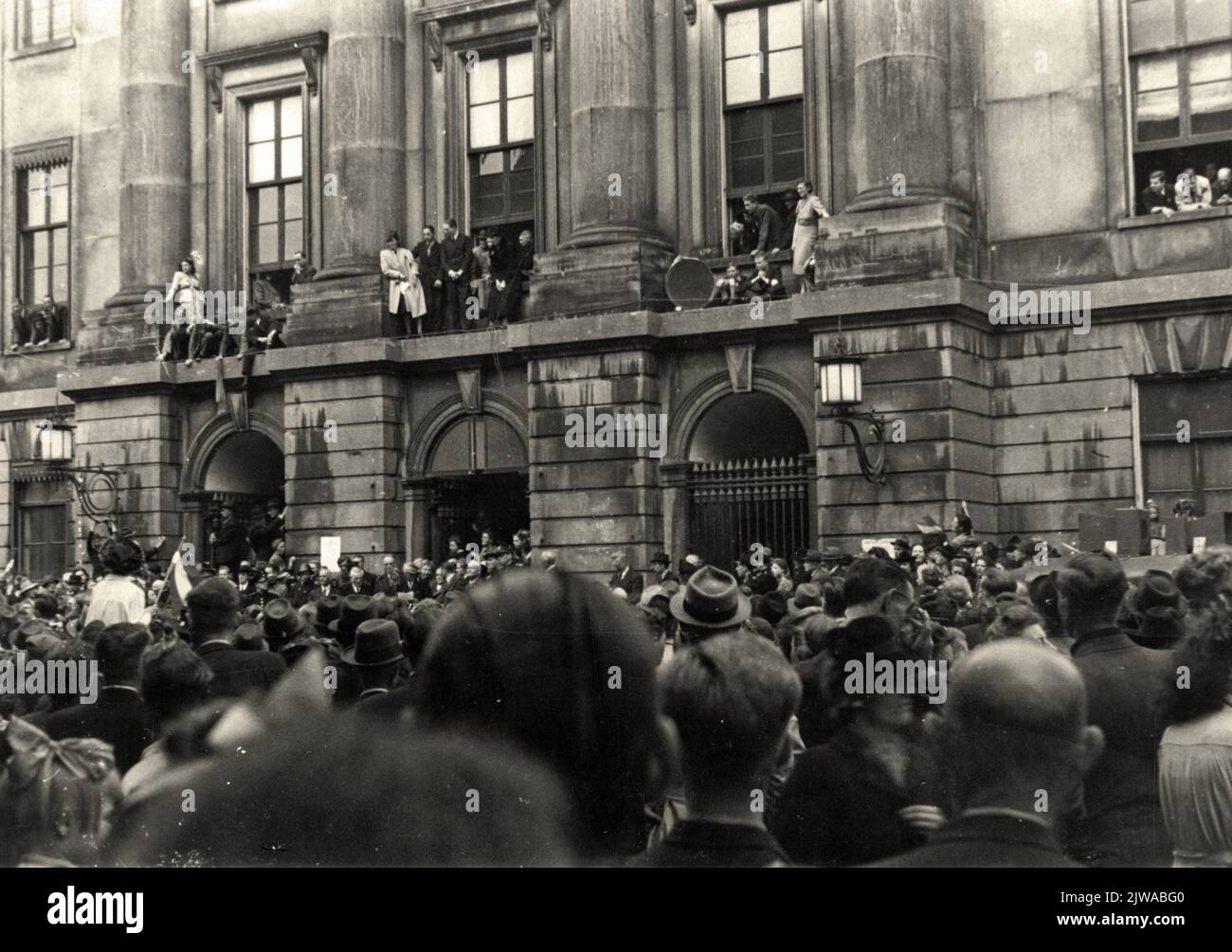 Image d'une foule devant l'hôtel de ville (Stadhuisbrug 1) à Utrecht lors de la lecture de la proclamation de la reine par le maire M. dr. Va-t'en. Ter Pelkwijk, lors de l'entrée des alliés. Banque D'Images