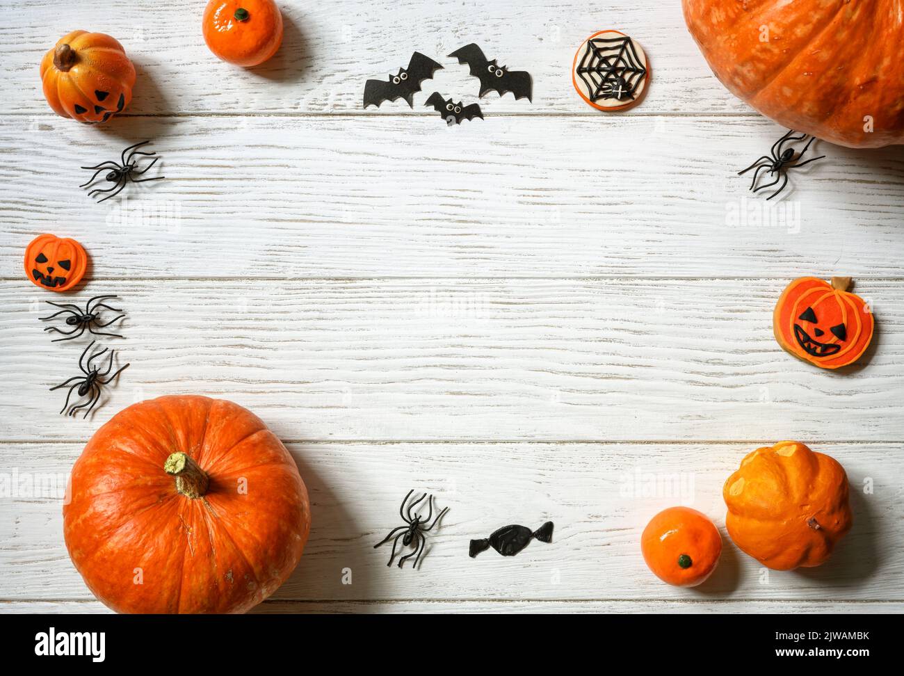 Arrière-plan Halloween, vue du dessus. Citrouilles et bonbons sur une table en bois blanc, plat. Cadre de la nourriture orange d'Halloween et des décorations sur des planches de bois avec Banque D'Images