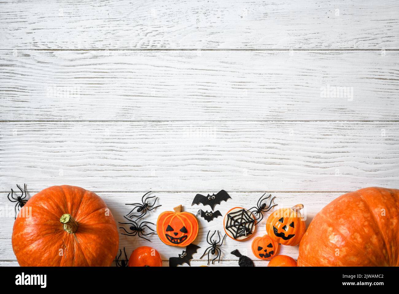 Arrière-plan Halloween, vue du dessus. Citrouilles et bonbons sur une table en bois blanc, plat. Halloween nourriture et décorations sur des planches de bois avec l'espace. Conception, Banque D'Images