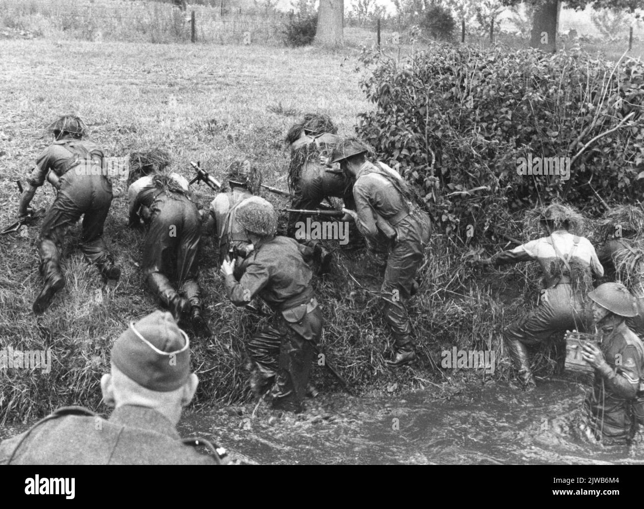 Images d'un exercice militaire sur le Kromme Rijn à Bunnik à l'occasion de l'anniversaire de 200 ans de l'Ecole-cadre des pionniers et de l'École des officiers de réserve des pionniers : un groupe de fantassins clameur après avoir traversé la rivière sur la rive. Banque D'Images