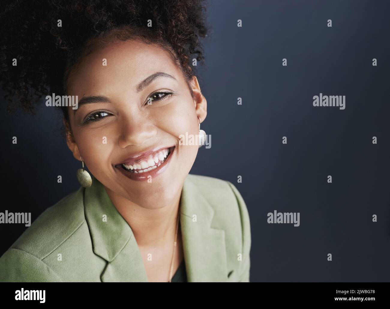 Exprimez-vous. Photo studio d'une jeune femme debout sur un fond sombre. Banque D'Images