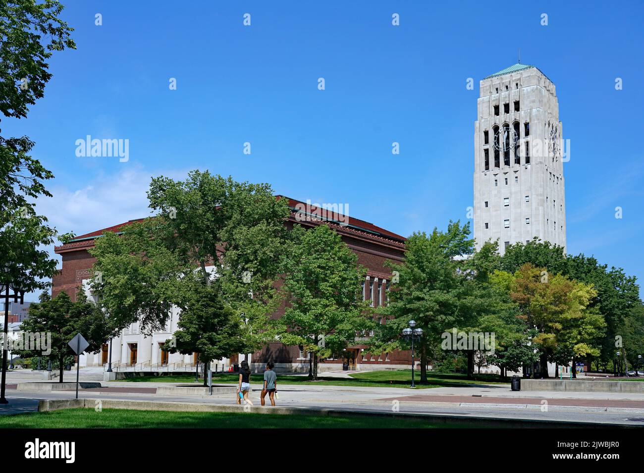 Ann Arbor, Michigan, États-Unis - août 2022 : les étudiants marchent sur le campus de l'Université du Michigan par une journée ensoleillée, avec Burton Memorial Tower dans le b Banque D'Images
