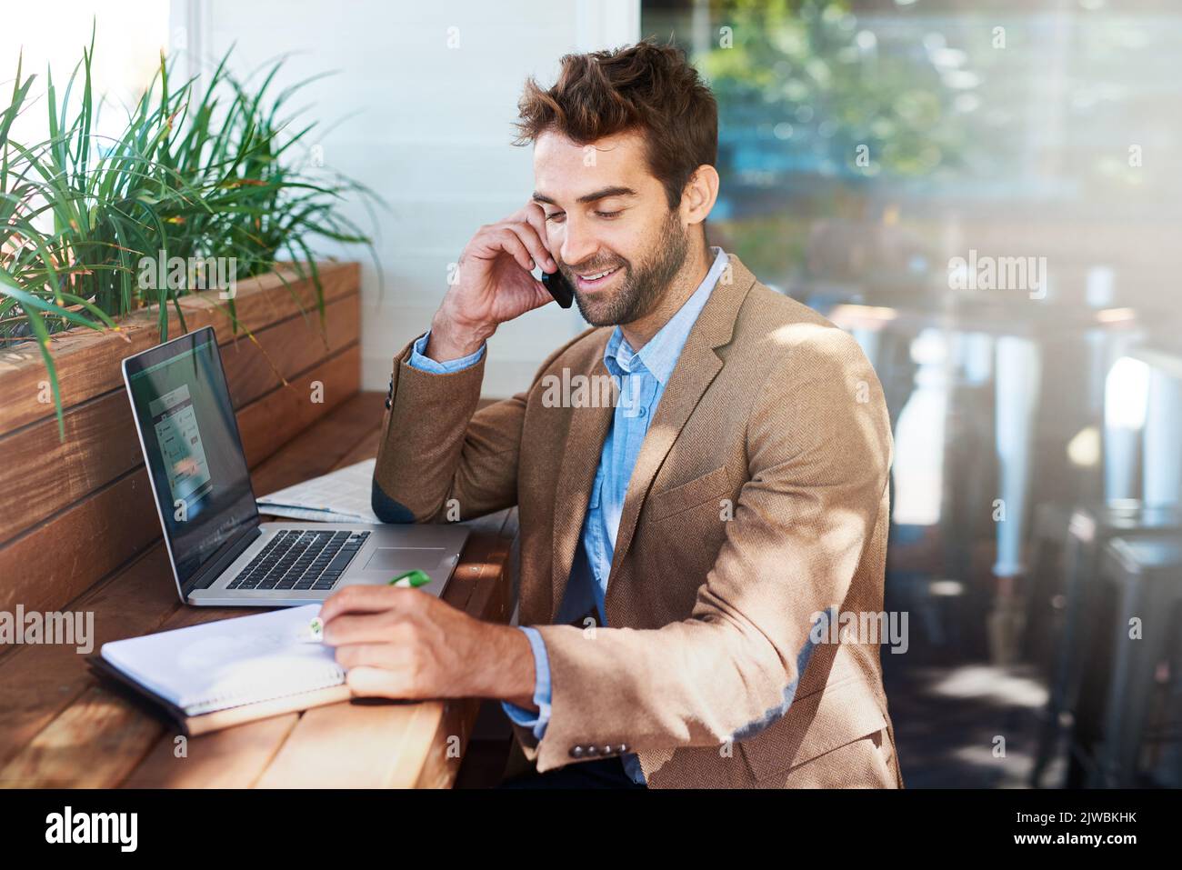Eh bien, gardez le contact. Un jeune entrepreneur parle au téléphone dans un café. Banque D'Images