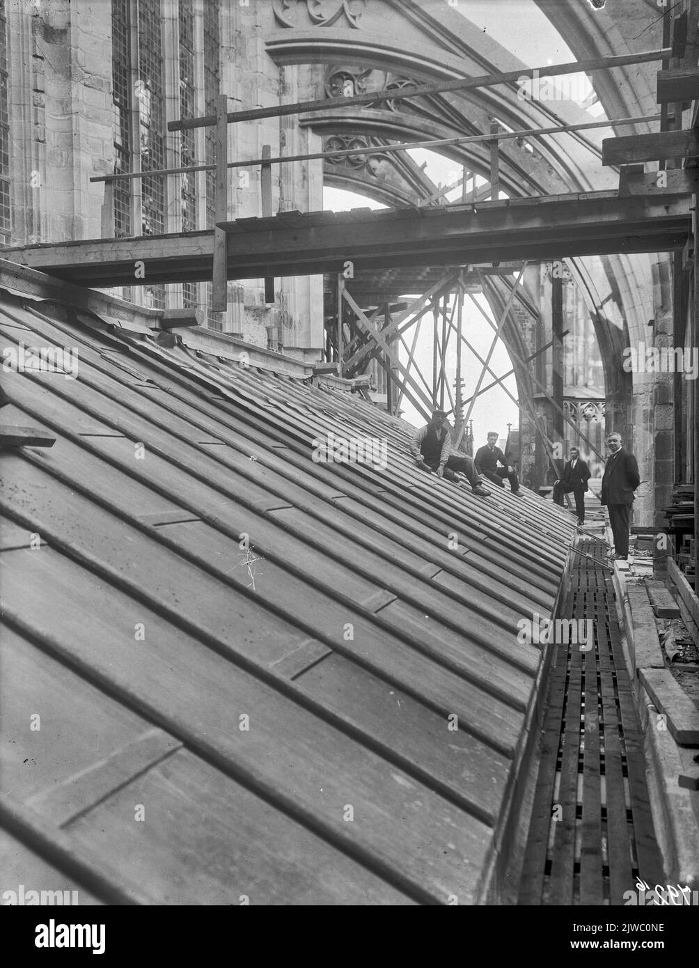 Vue sur le toit du couloir du chœur, lors de la restauration de la façade sud du Domkerk à Utrecht, avec quelques plombiers qui frappent le plomb. Banque D'Images
