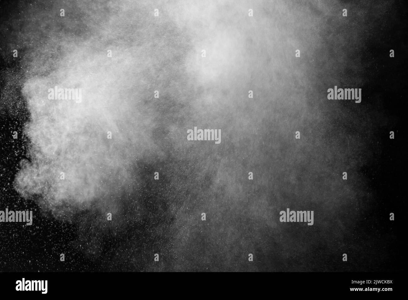 Vapeur blanche bouclés qui s'élève et projection d'eau dans différentes directions isolée sur un fond noir à superposer. Évaporation du liquide an Banque D'Images