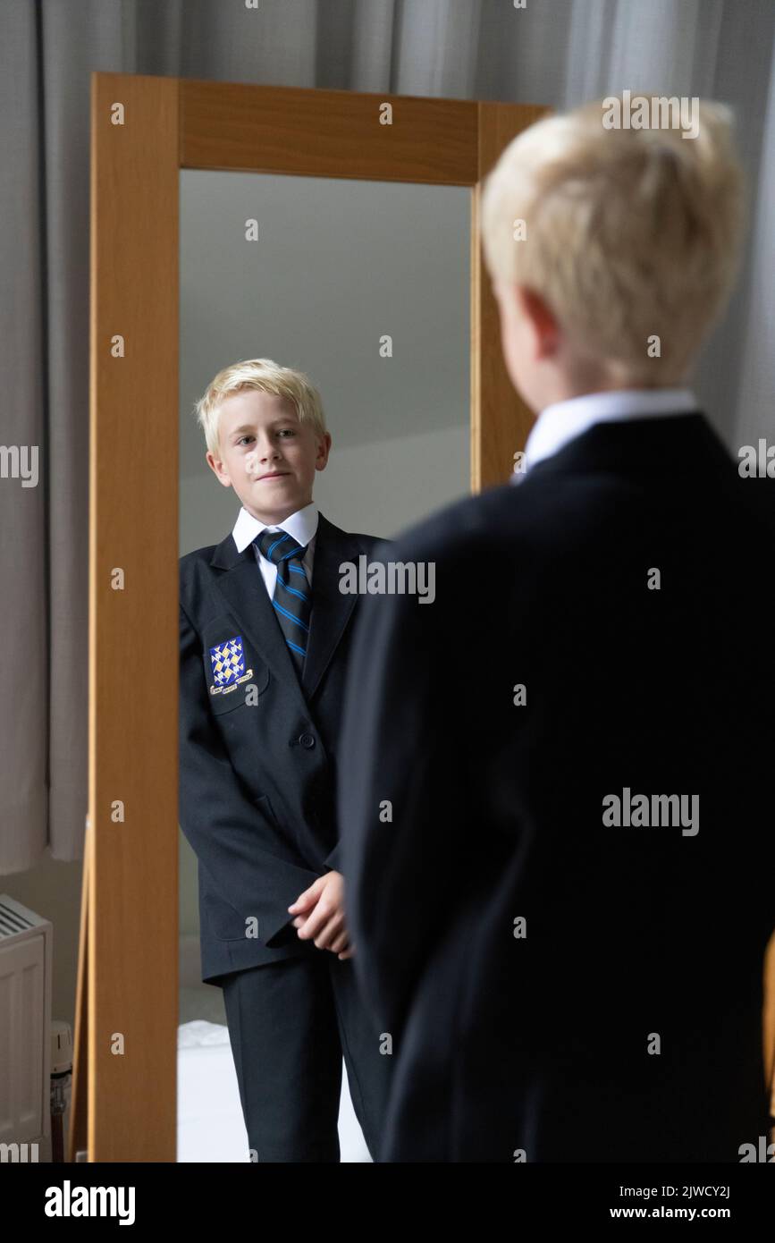 Le premier jour de retour à l'école, un garçon se prépare dans son nouvel uniforme avant son premier jour à l'école secondaire, Angleterre, Royaume-Uni Banque D'Images
