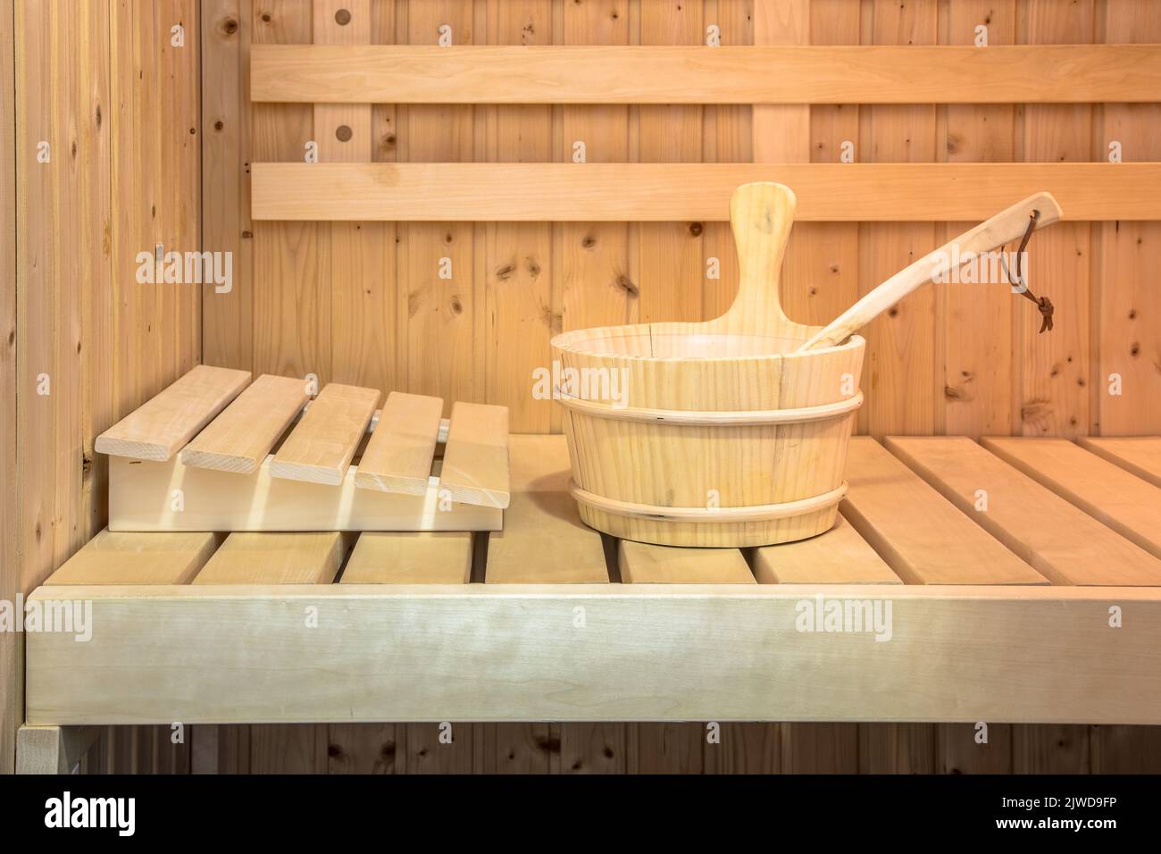 Seau en bois sur le siège à l'intérieur du sauna finlandais Banque D'Images
