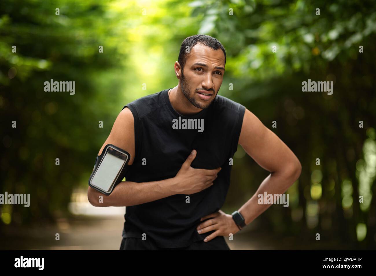 Sportif afro-américain souffrant de douleurs cardiaques, s'entraîner à l'extérieur Banque D'Images