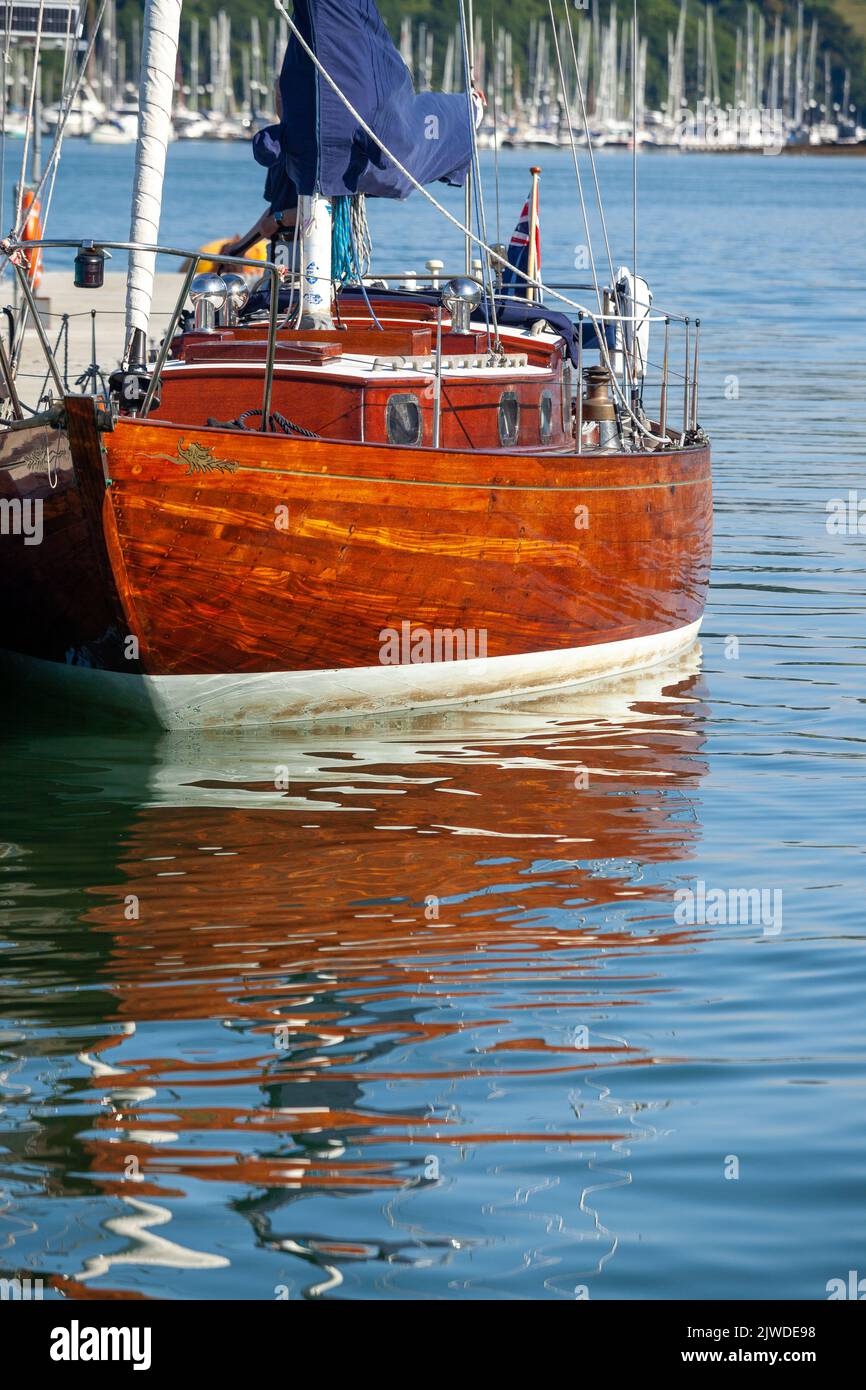 Réflexions sur l'eau d'un voilier classique en bois dans le port de Dartmouth. Banque D'Images