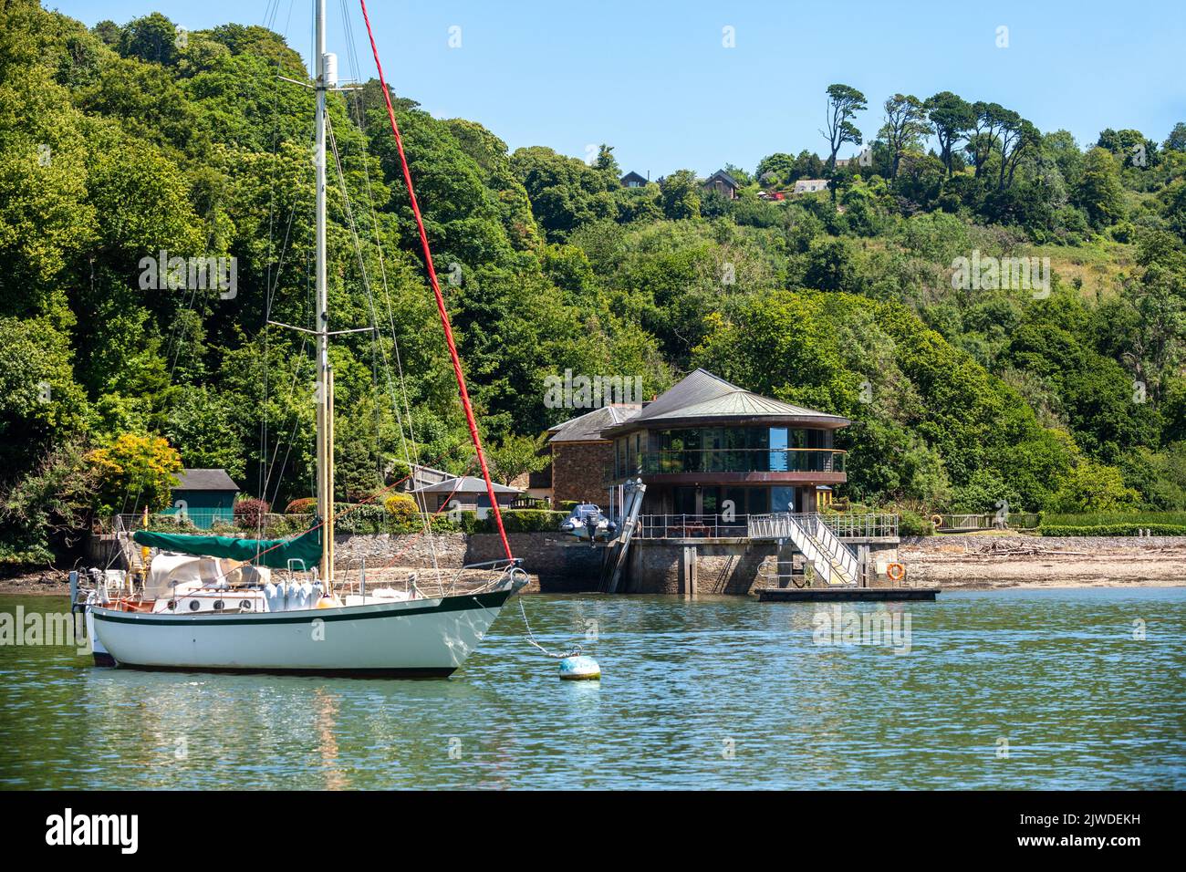 Une maison moderne et chère avec un yacht amarré à proximité sur la rivière Dart, Dartmouth Banque D'Images