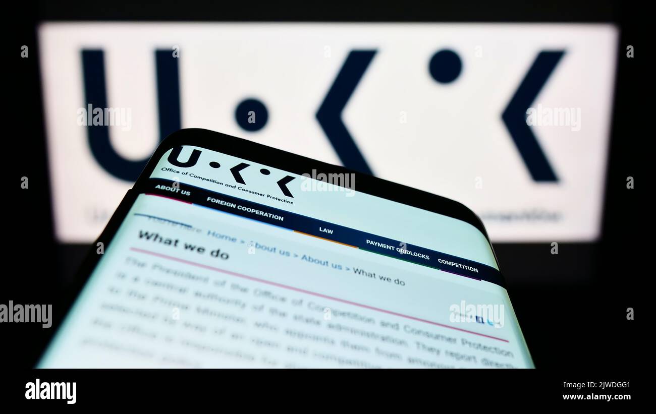 Smartphone avec la page web de l'autorité polonaise de la concurrence UOKiK sur l'écran devant le logo. Faites la mise au point dans le coin supérieur gauche de l'écran du téléphone. Banque D'Images