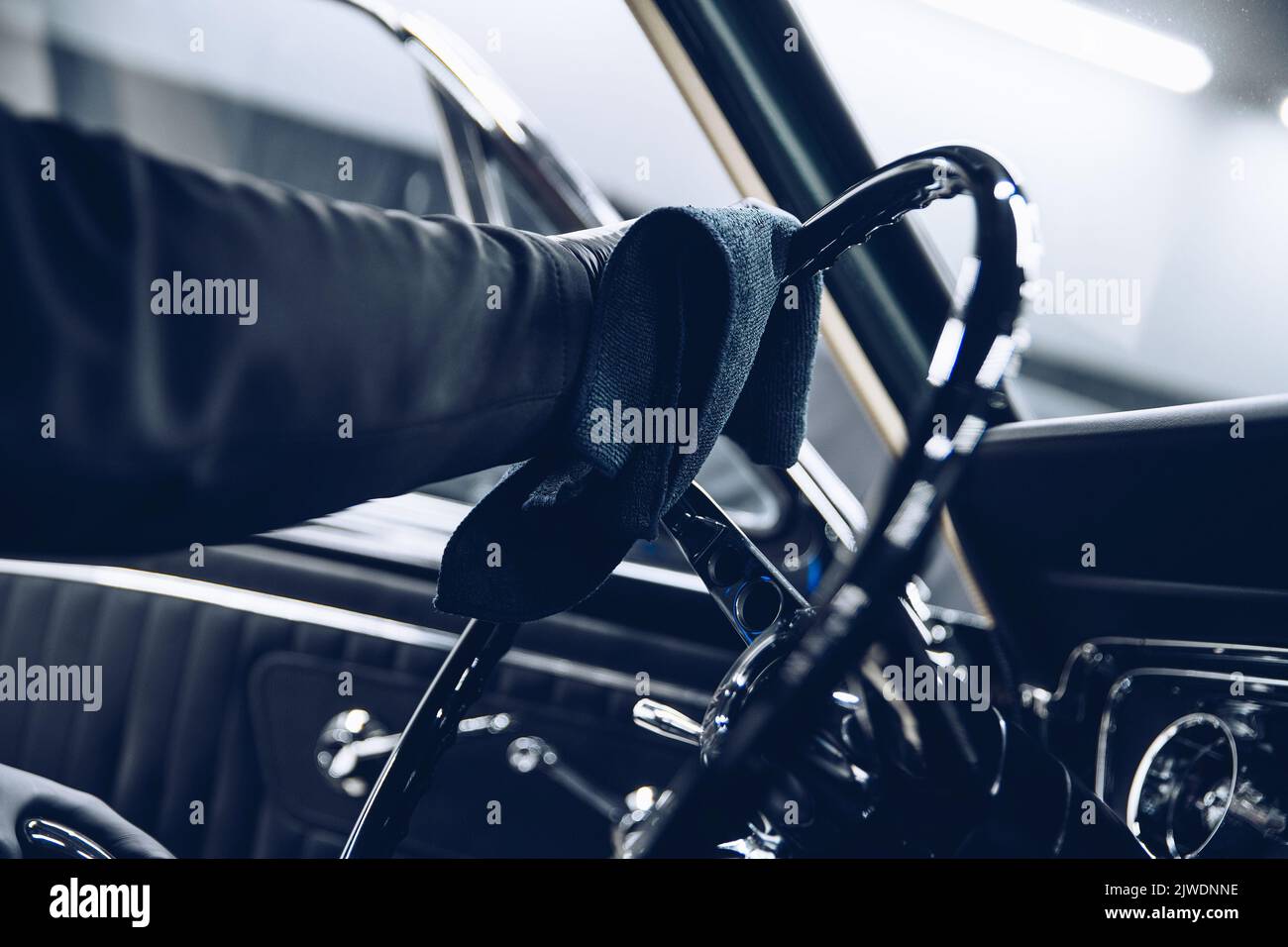 Un employé d'un lave-auto ou d'un studio de nettoyage de voiture nettoie un volant Banque D'Images
