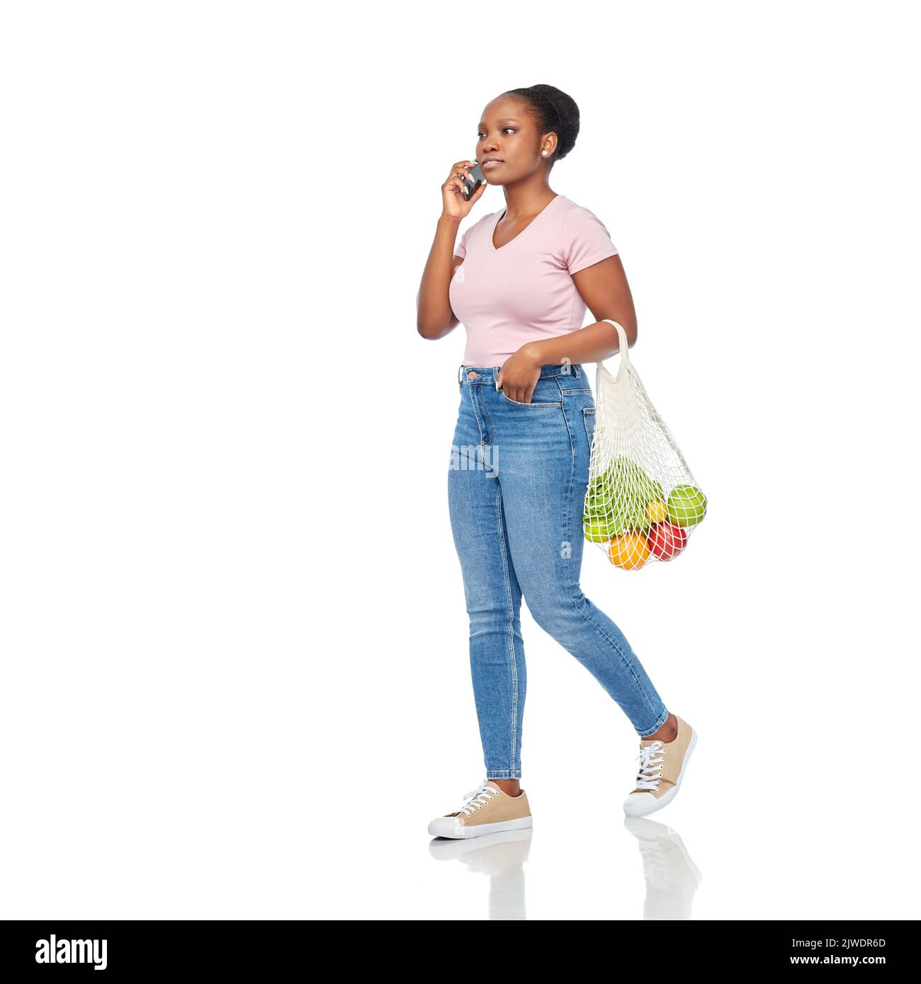 femme avec de la nourriture dans un sac en filet appelant sur un téléphone intelligent Banque D'Images