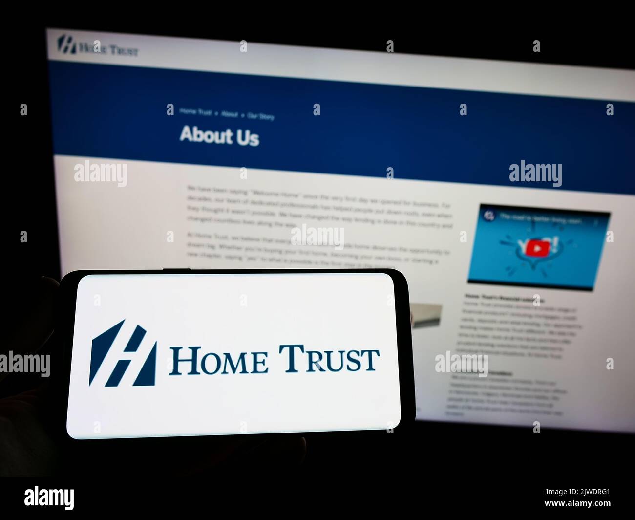 Personne détenant un smartphone avec le logo de la Compagnie de fiducie Home Canada prêteur à l'écran devant le site Web. Mise au point sur l'affichage du téléphone. Banque D'Images