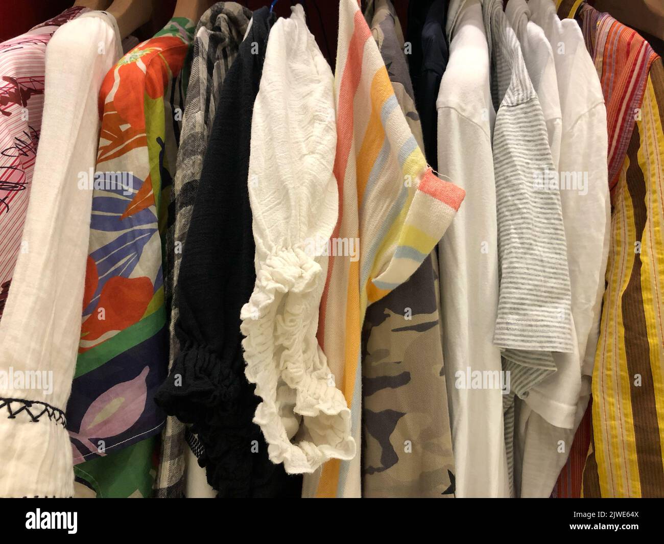 Gros plan de divers vêtements pour femmes et hommes suspendus dans une garde-robe Banque D'Images