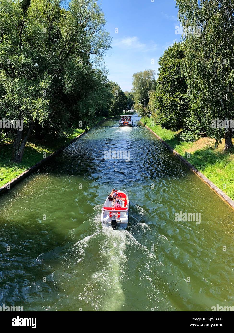 Vue arrière d'un bateau naviguant dans un canal en été près de la ville de Gizycko, quartier des lacs de Masurian, Pologne Banque D'Images