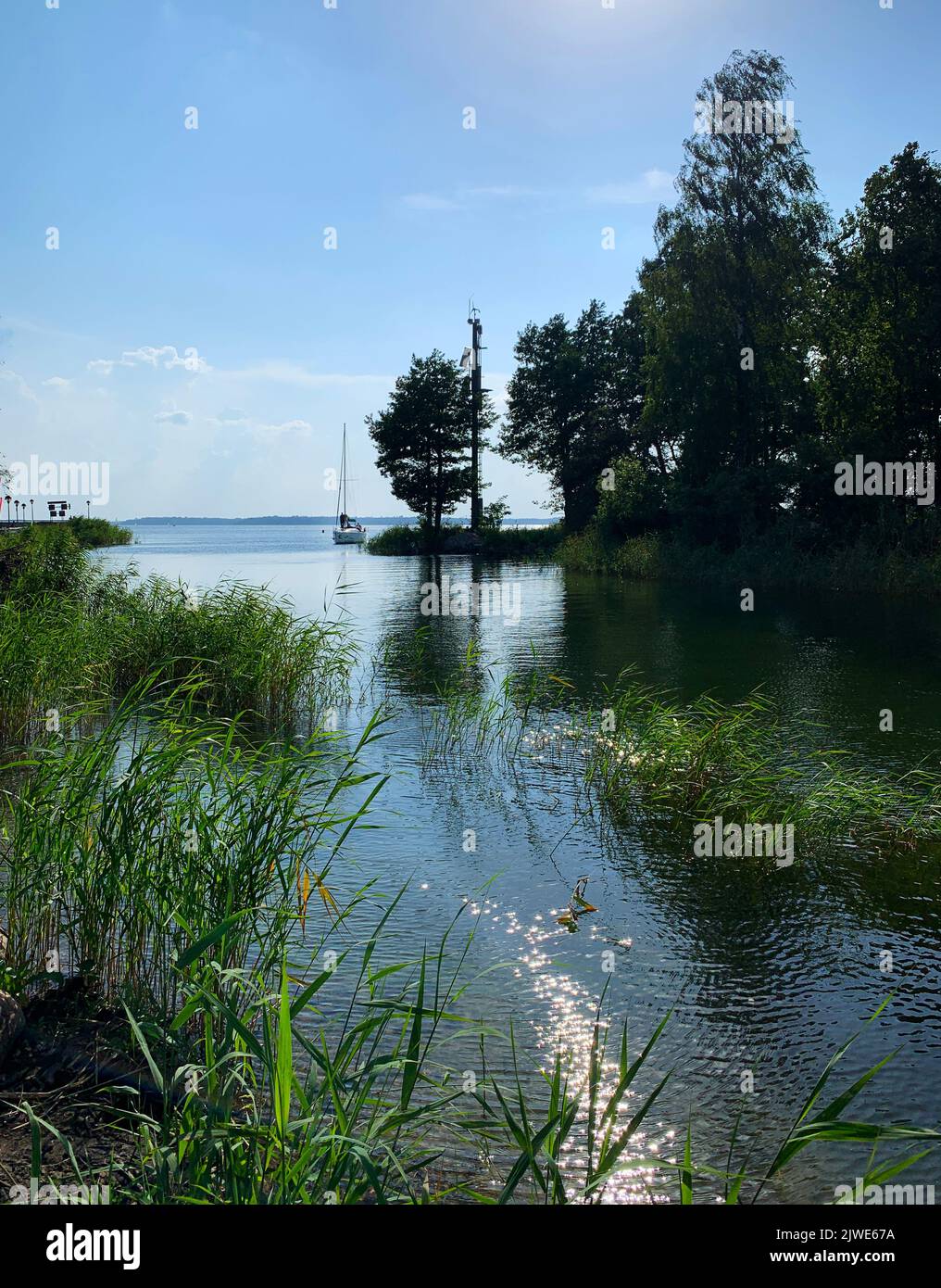 Bateau éloigné naviguant sur un lac en été près de Gizycko, Pologne Banque D'Images