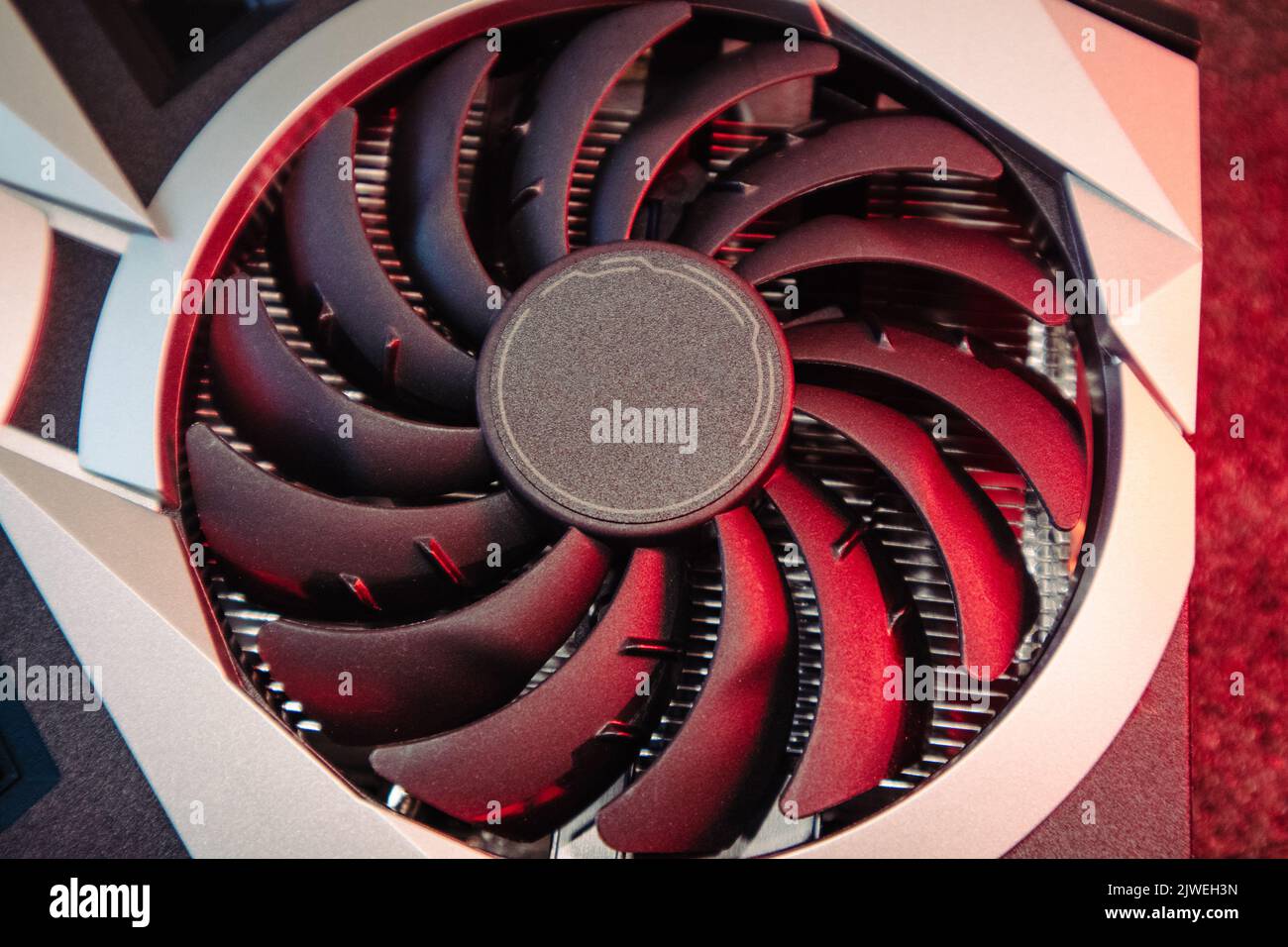 Ventilateur plus froid sur la carte graphique vidéo GPU, gros plan sous  lumière rouge avec mise au point sélective, détails matériels du PC.  Composants d'un ordinateur puissant pour les gamers ou Photo