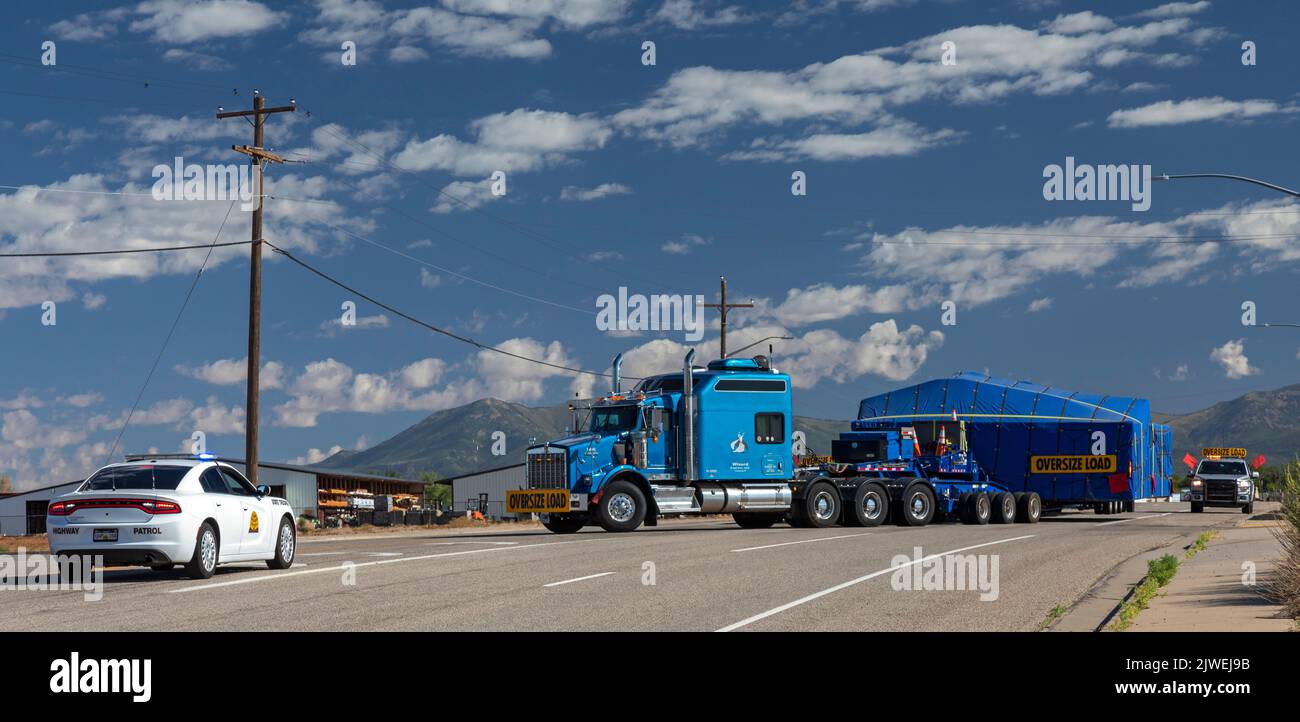 Blanding, Utah - protégé par la patrouille routière de l'Utah, un camion qui déplace une charge surdimensionnée tente de tourner de l'US Highway 191 sur une route latérale. Banque D'Images