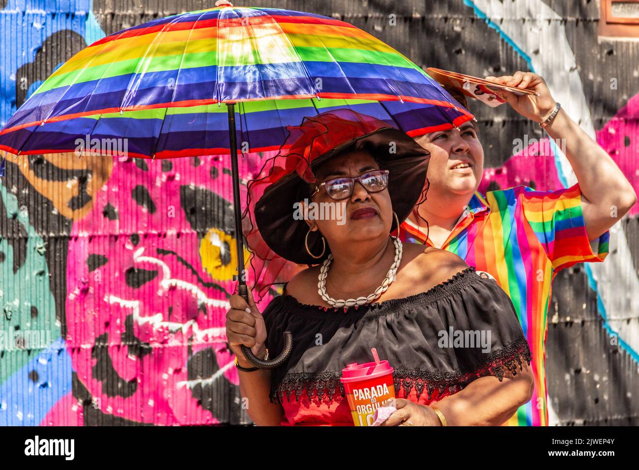 Goias, Brésil – 05 septembre 2022 : deux personnes avec parapluie et vêtements colorés, à la recherche. Photo prise lors de la parade LGBT à Goiania. Banque D'Images