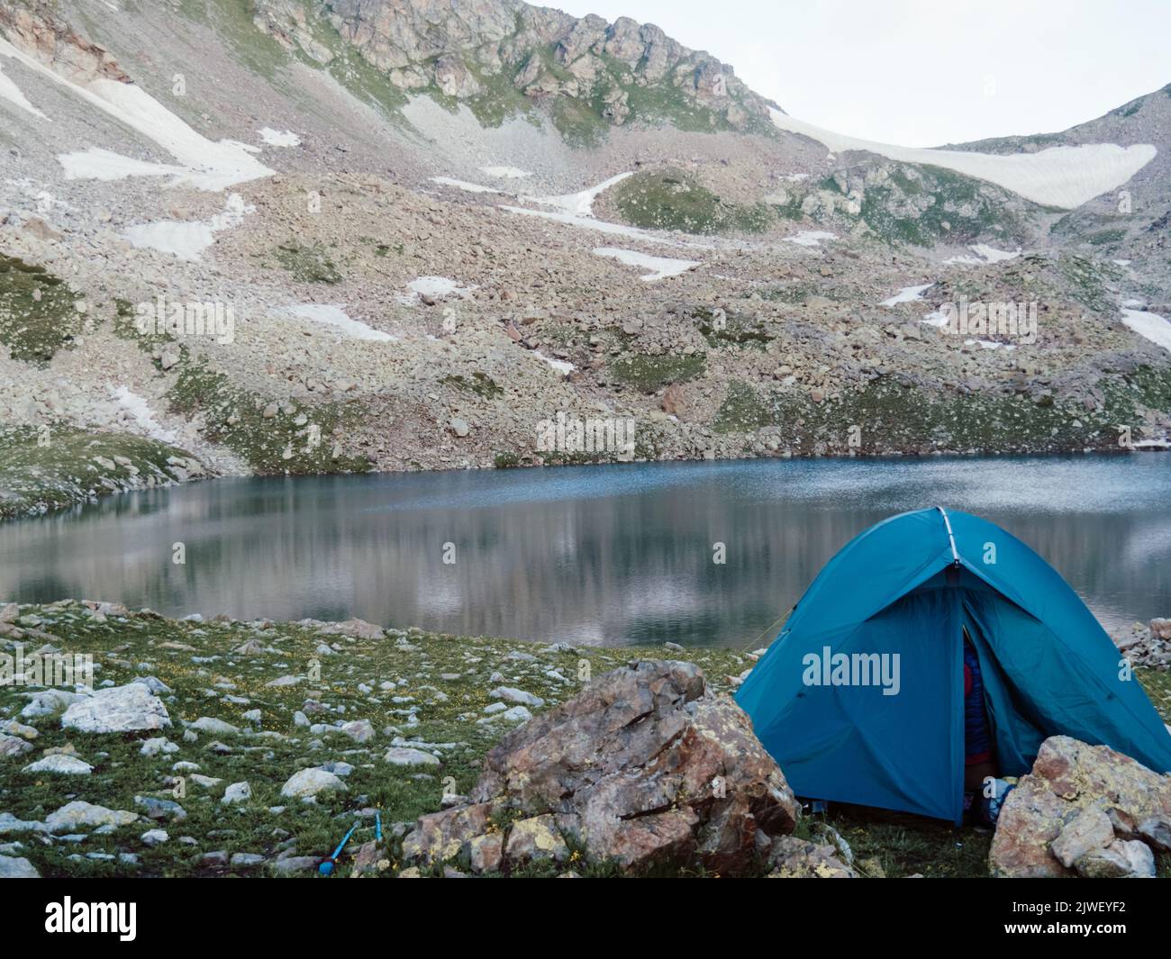 Tente de camping avec fond de lac. Paysage de montagne avec tente bleue seule près du lac sur la colline Banque D'Images