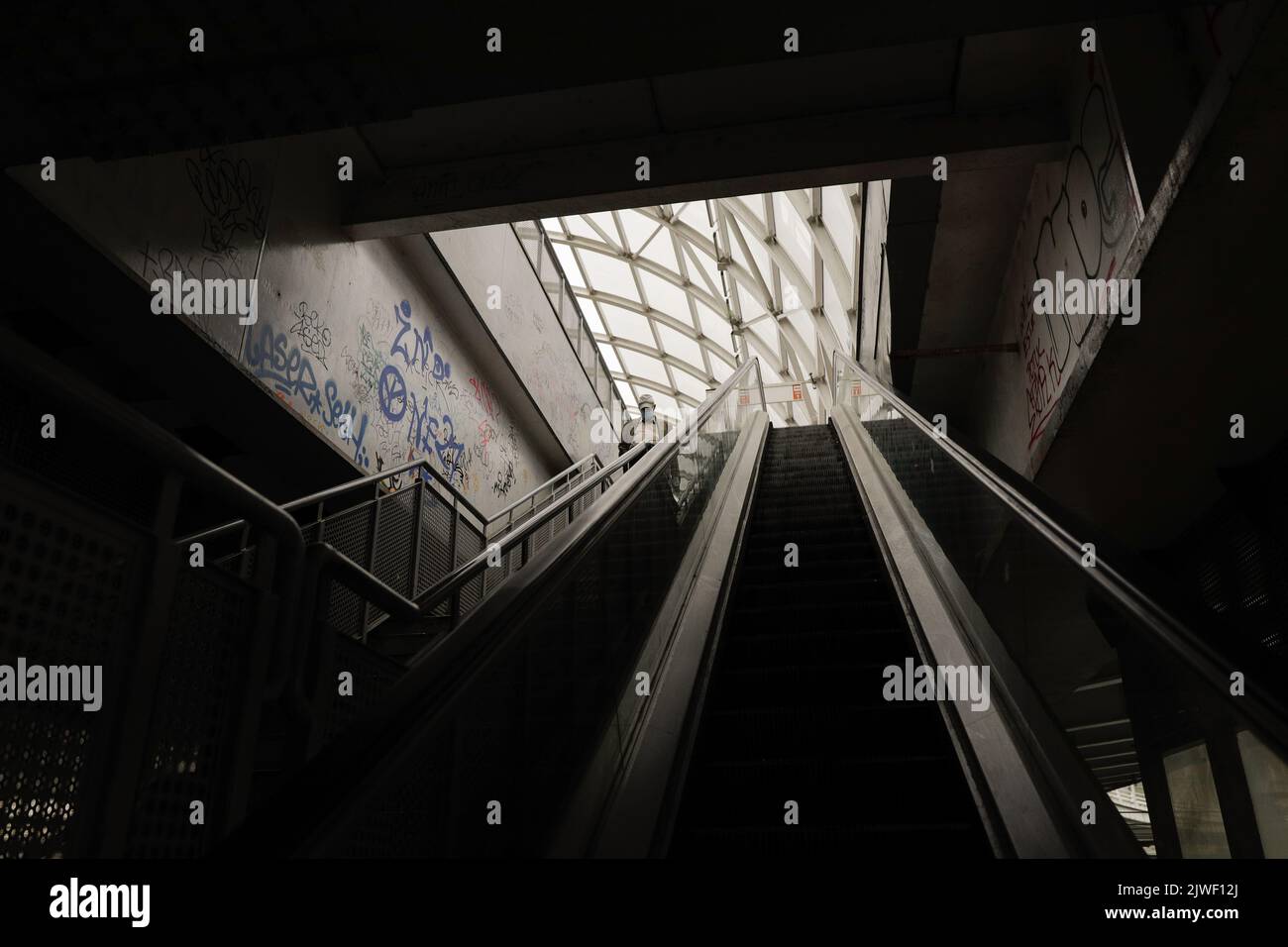 Bucarest, Roumanie - 3 septembre 2022: Un homme de haut niveau descend un escalier sombre, sale et vandalisé à Bucarest. Banque D'Images