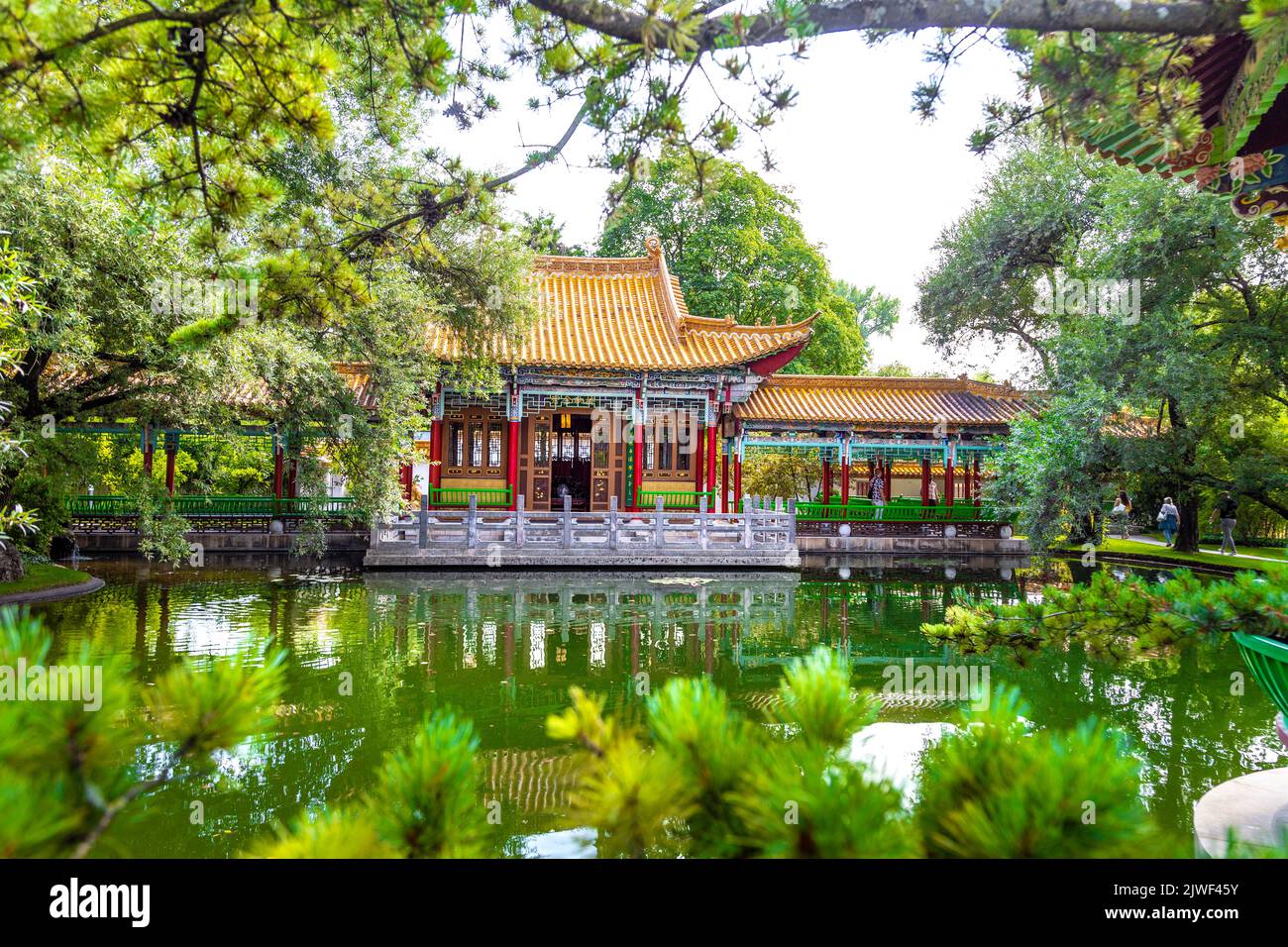 Pavillon chinois coloré donnant sur un étang au jardin de Chine (Chinagarten Zürich), Seefeld, Zurich, Suisse Banque D'Images