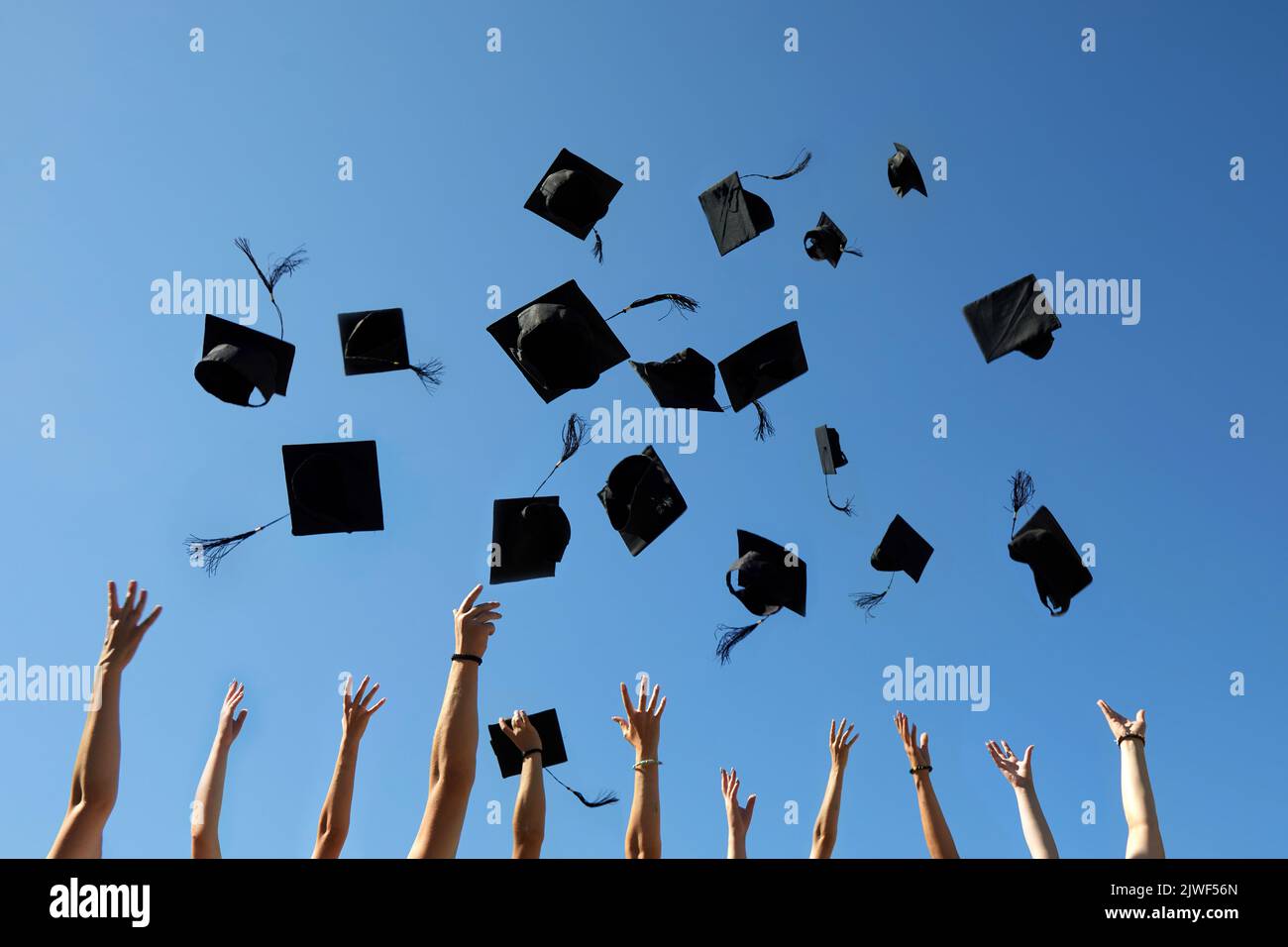 Capsules de graduation projetées dans l'air sur le ciel bleu Banque D'Images