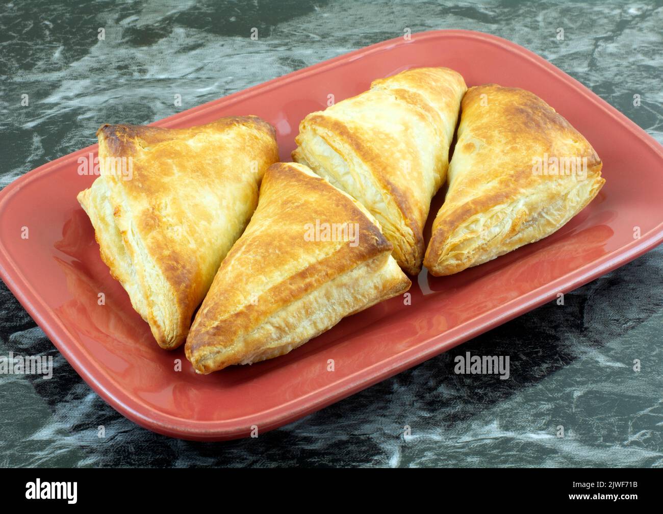 Petit déjeuner cuit pommes rotation pâtisseries sur plaque rouge de service sur la table Banque D'Images
