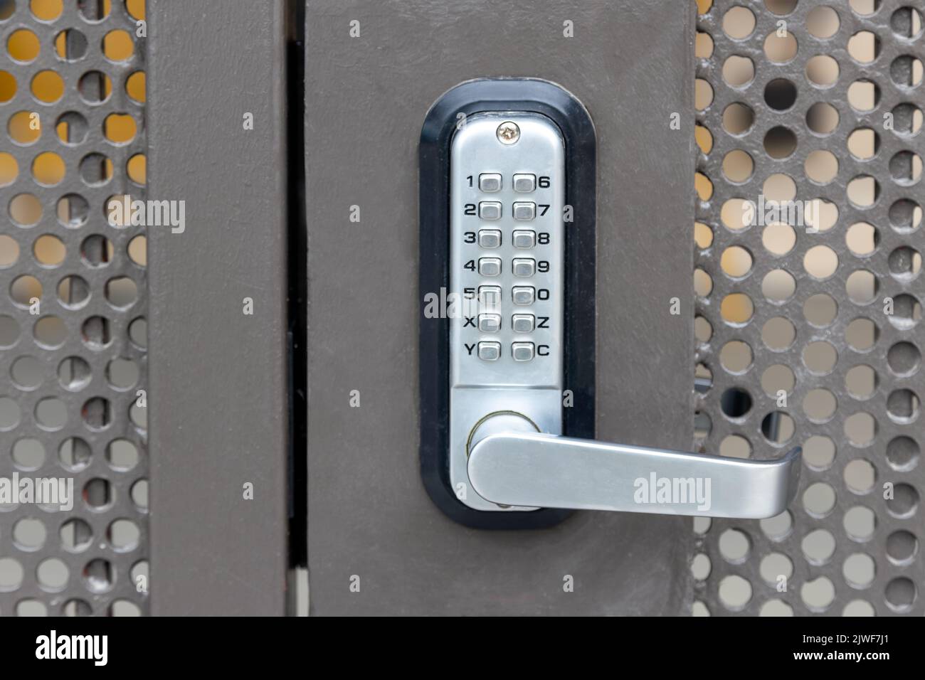 Porte de sécurité privée verrouillée en métal avec clavier à système de verrouillage combiné à bouton-poussoir et poignée de poignée de porte argentée métallique Banque D'Images