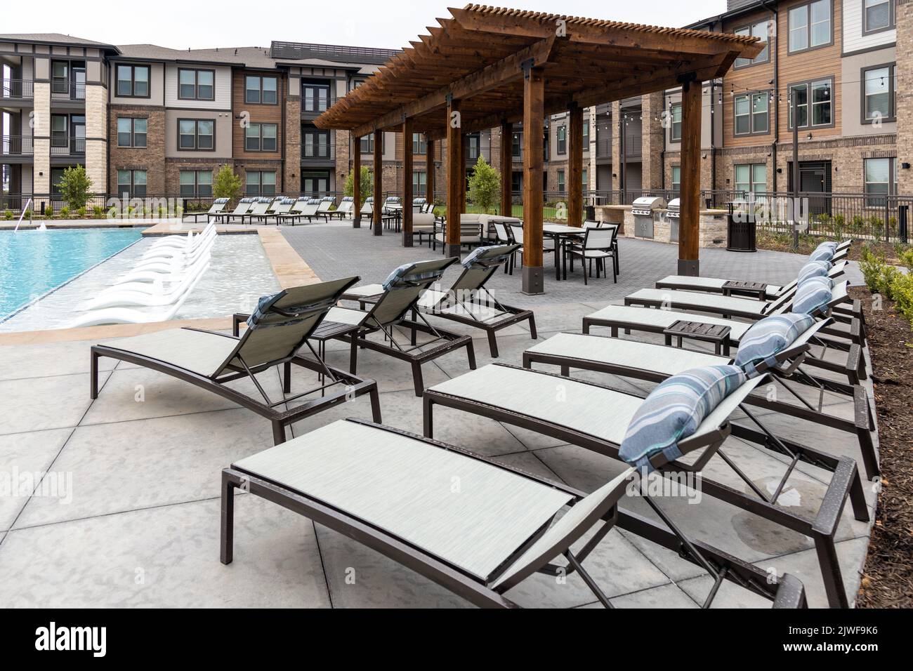Vue sur les chaises longues, la piscine et la salle à manger sur le toit dans le complexe résidentiel moderne arrière ou avant cour Banque D'Images