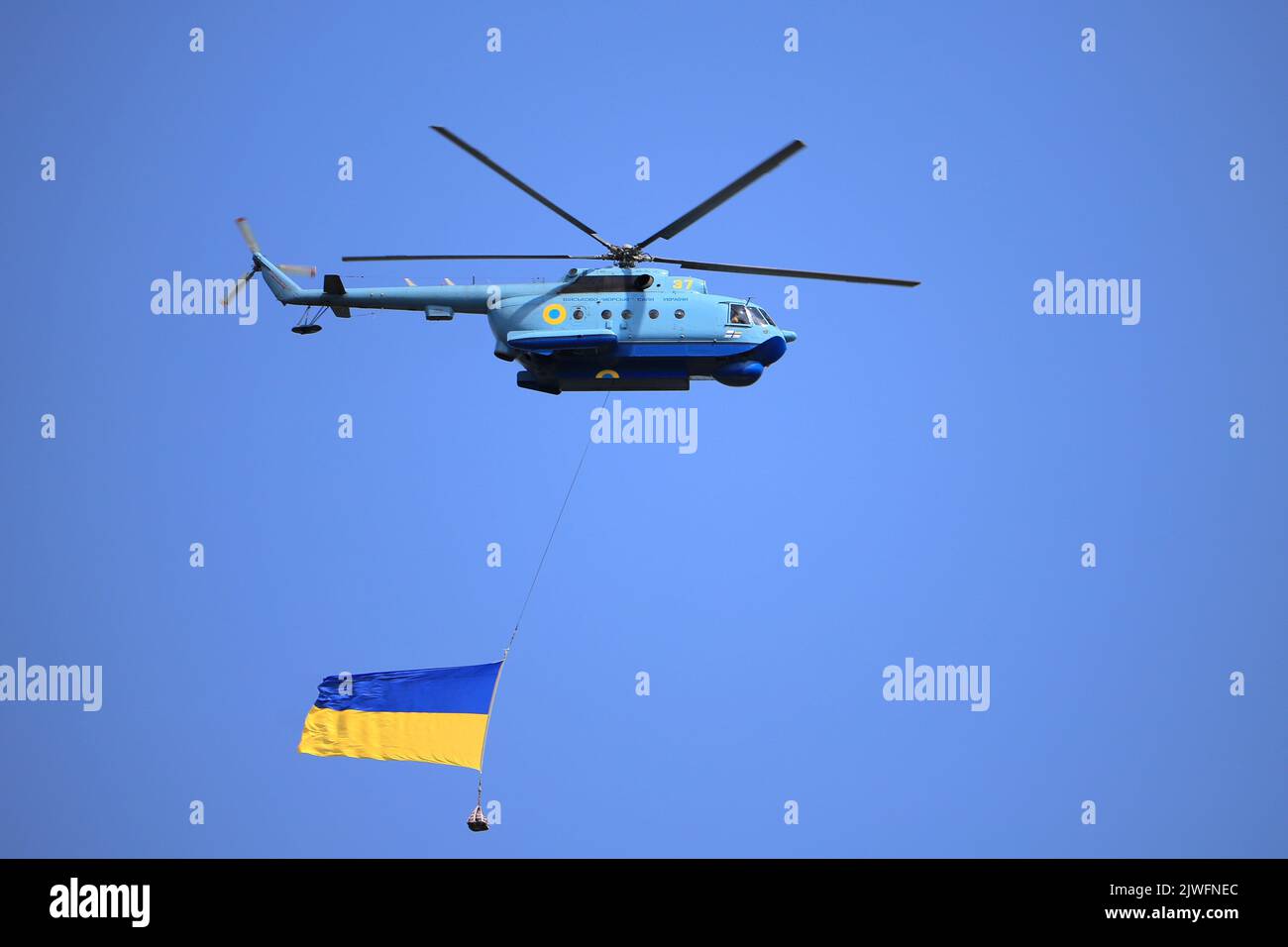 L'hélicoptère militaire MI-14 vole avec le grand drapeau de l'Ukraine Banque D'Images L'hélicoptère militaire MI-14 vole avec le grand drapeau de l'Ukraine Banque D'Images