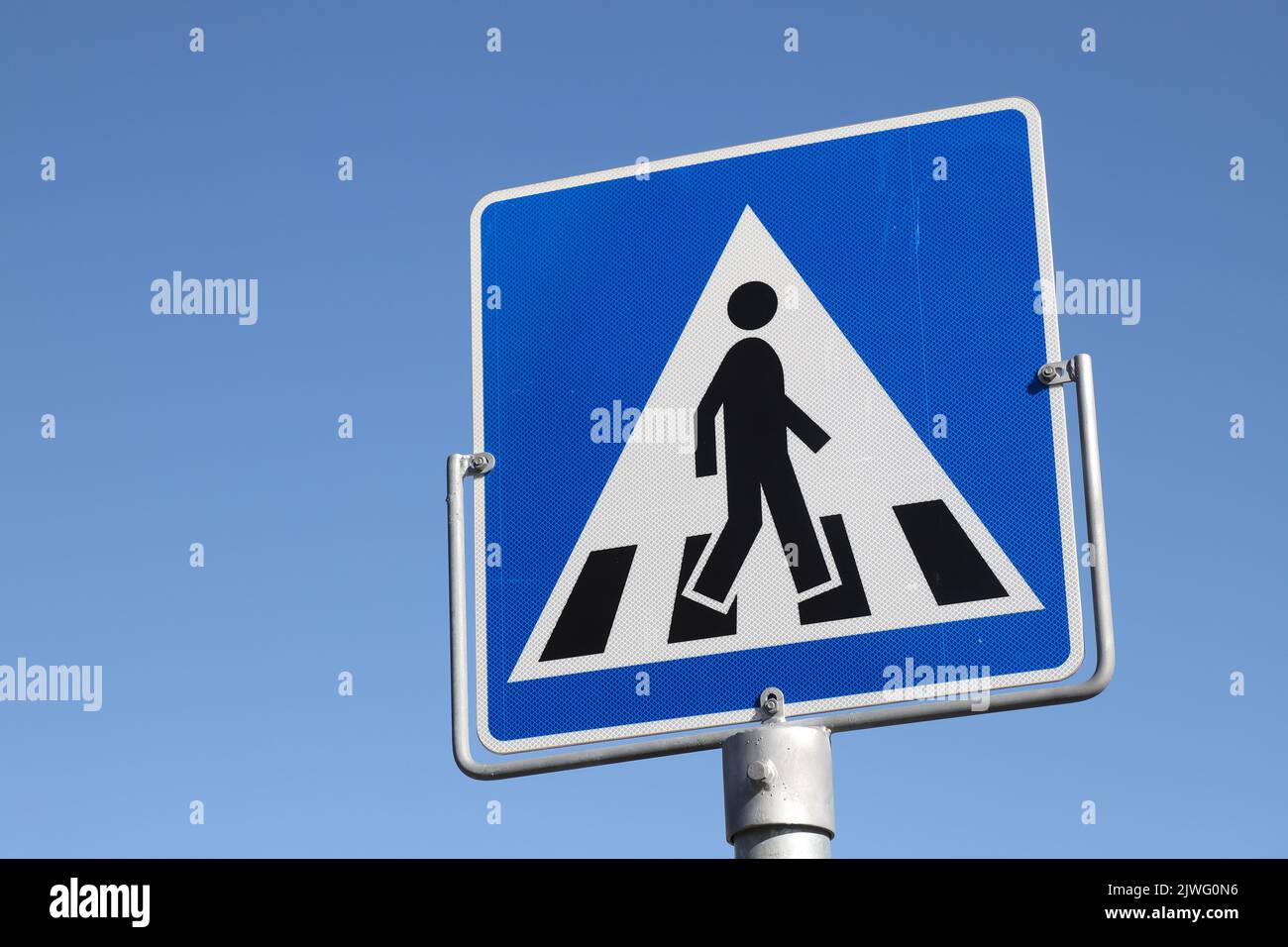Panneau de signalisation pour piétons contre un ciel bleu. Banque D'Images