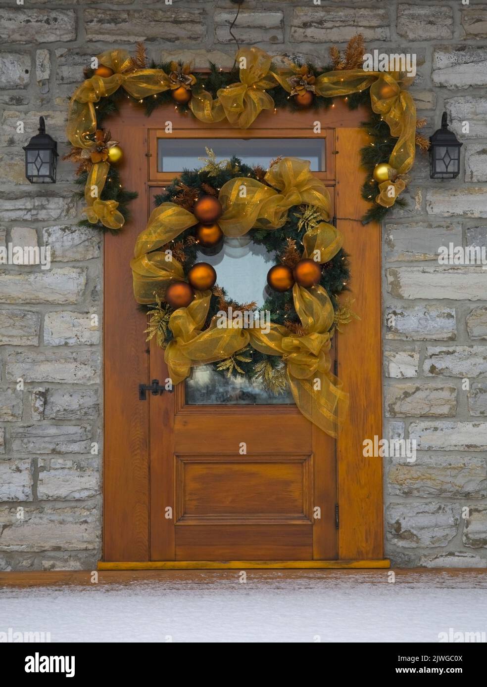 Porte d'entrée en bois avec décorations de Noël sur une ancienne maison de style cottage Canadiana vers 1750. Banque D'Images